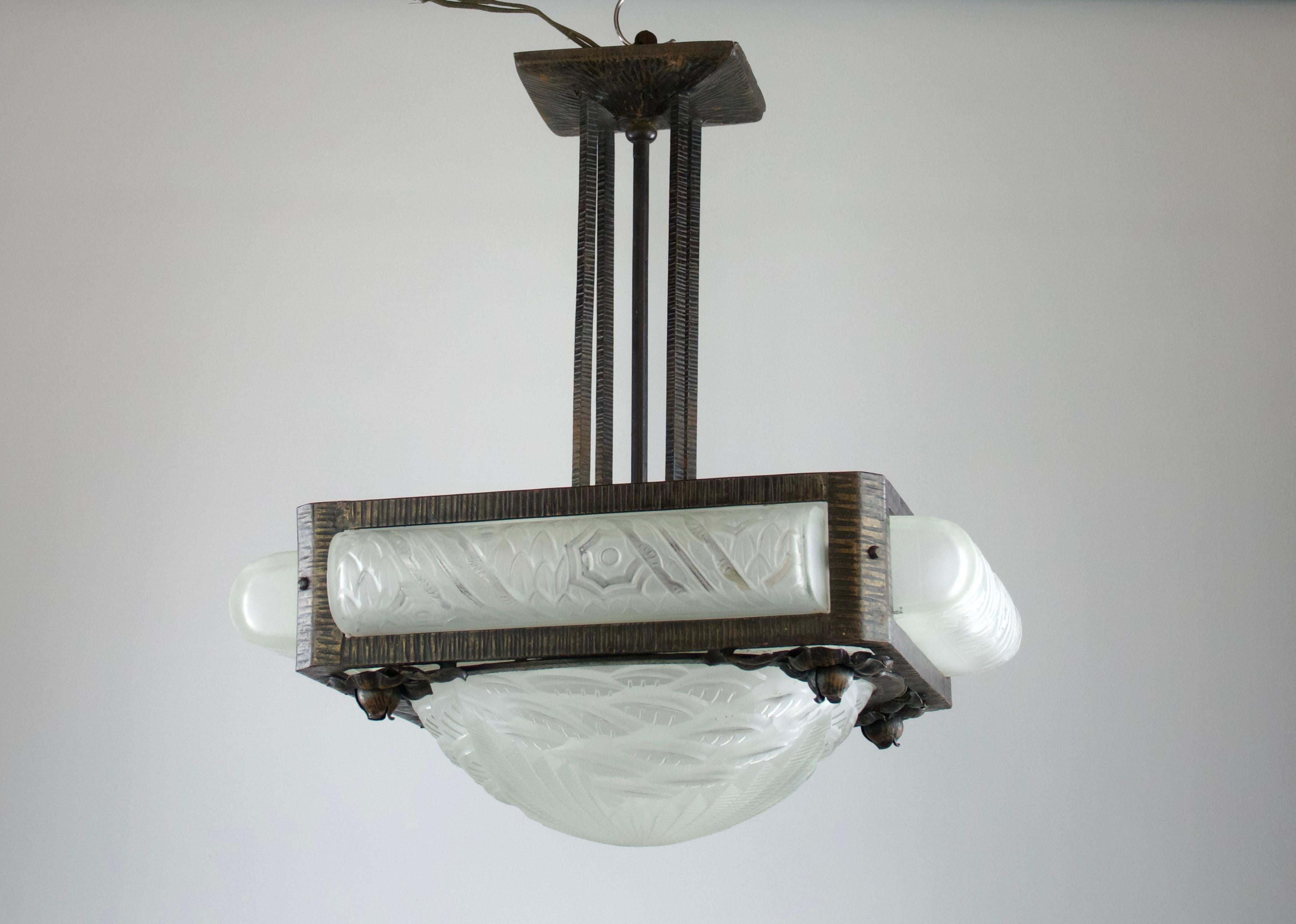 Superb Charles Schneider art deco chandelier suspension from the 1920s. Ironwork decorations of roses and geometric forms in the Edgar Brandt style. Molded glass with decorations of scales, flowers and geometric forms.

Signed.

Excellent condition.