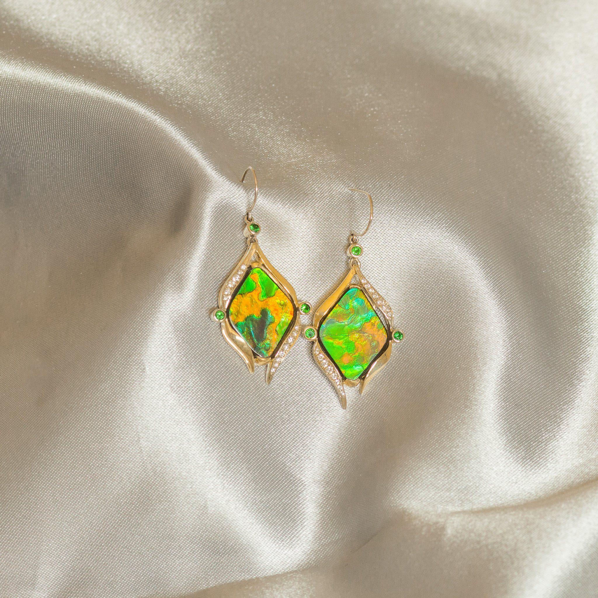 Mark Schneider designed, AA grade 6.5CT freeform Ammolite set in 14K gold accented with 0.24CT tsavorites and 0.27CT diamonds. These one-of-a-kind earrings feature exquisite naturally stabilized Ammolite gemstones. These natural freeform Ammolite