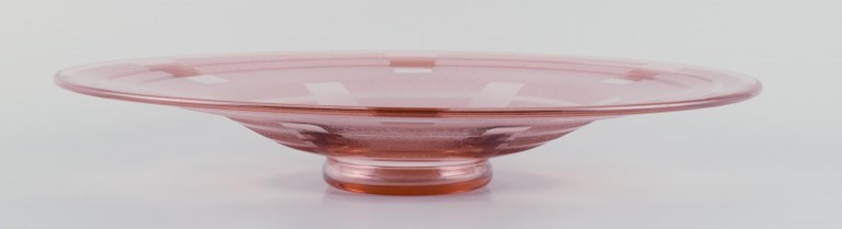 Schneider, Frankreich. 
Colossal Art Deco Rosa Kunstglasschale aus Kunstglas.
Geometrisches Muster in mattiertem Glas.
Ungefähr 1940.
Auf dem Sockel gestempelt.
In ausgezeichnetem Zustand.
Abmessungen: Durchmesser 41,5 cm, Höhe 6,5 cm.