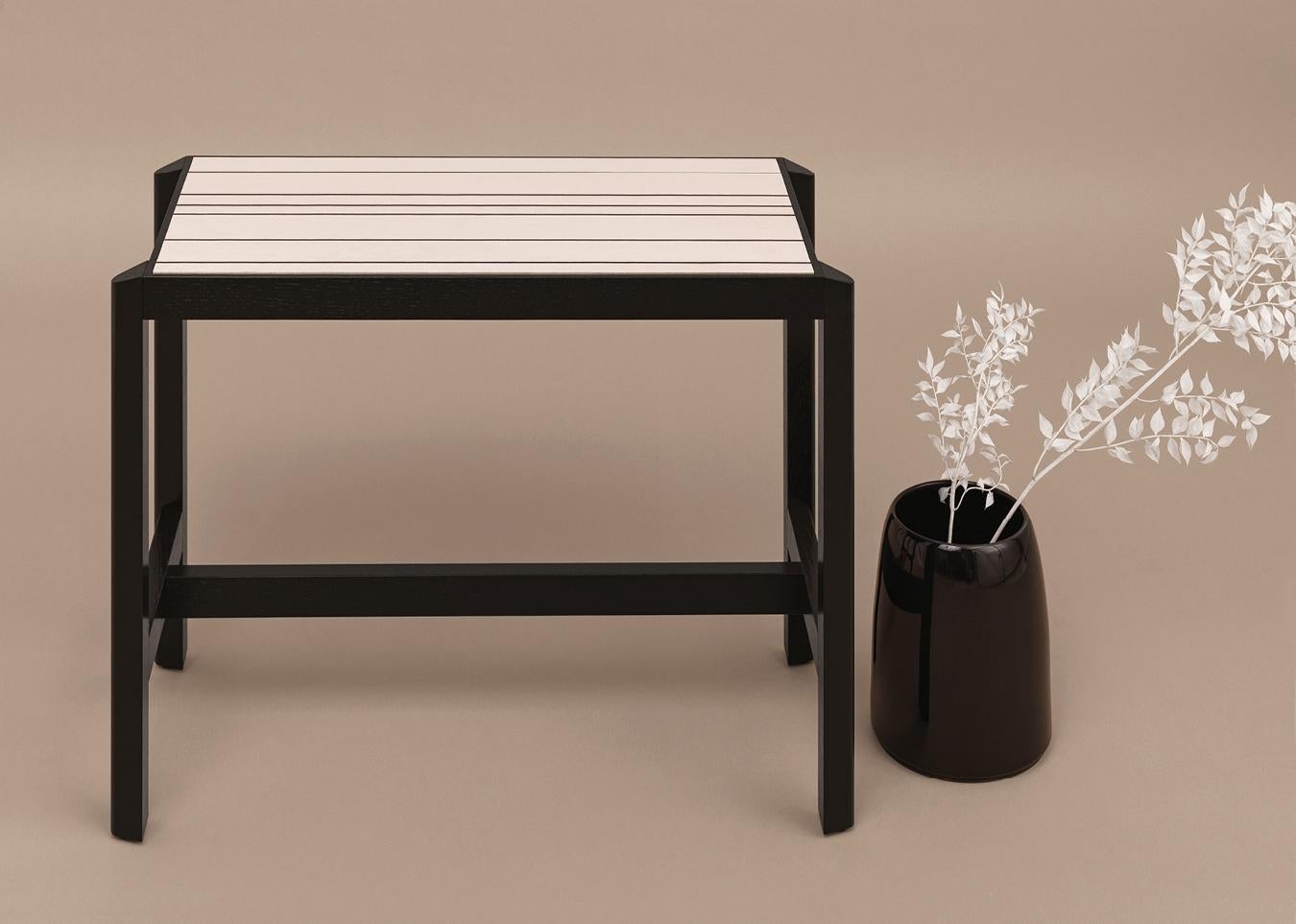 Mesa consola L
de madera maciza con acabado lacado de poro abierto en .46 negro, inserto de baldosas cerámicas.

La consola JUSTE es una pieza de lujo. La encimera consiste en una única baldosa de cerámica de gran tamaño, hecha a medida en