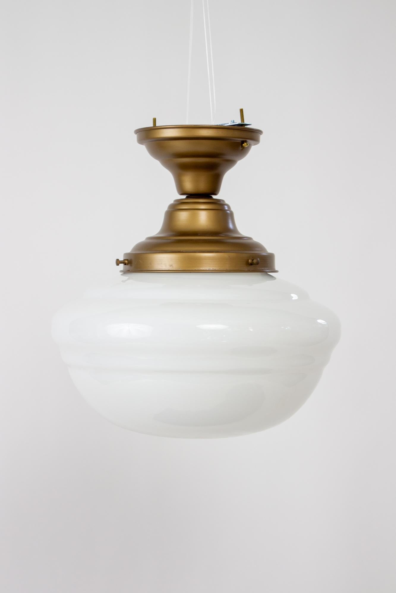 1930’s schoolhouse milk glass flush mount fixture. Glass is a Traditional schoolhouse glass shade. Mounted on a new fixture, satin antique brass finish , UL listed, with porcelain sockets. Excellent for a hallway or ceiling, and with a height of