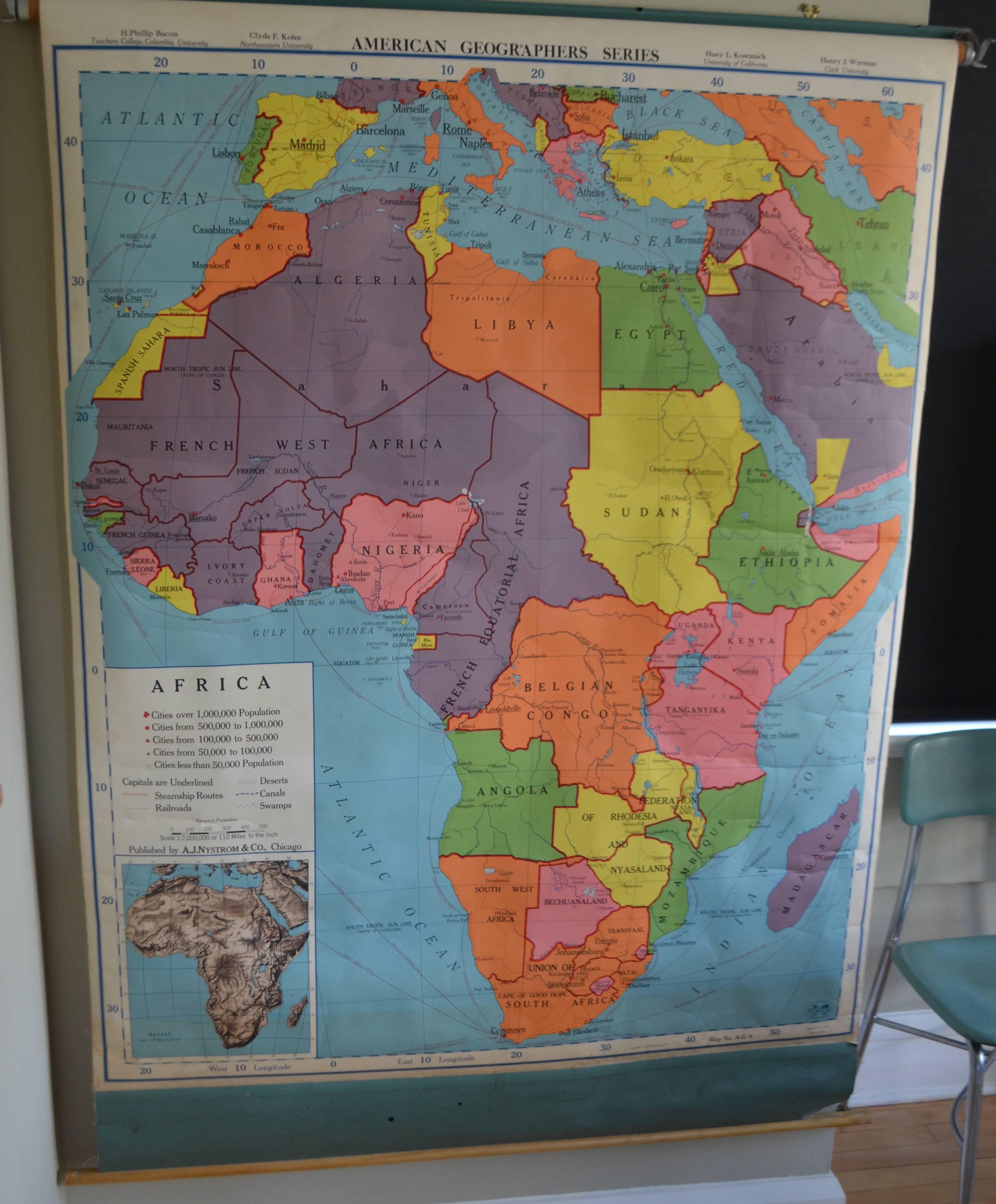 Classroom geography map of Africa, 1957 edition. Mounted on pulldown wooden roller with steel wall bracket. The colors on this map are rich, vivid and as compelling to behold as the African continent itself. The Dark Continent illuminated in