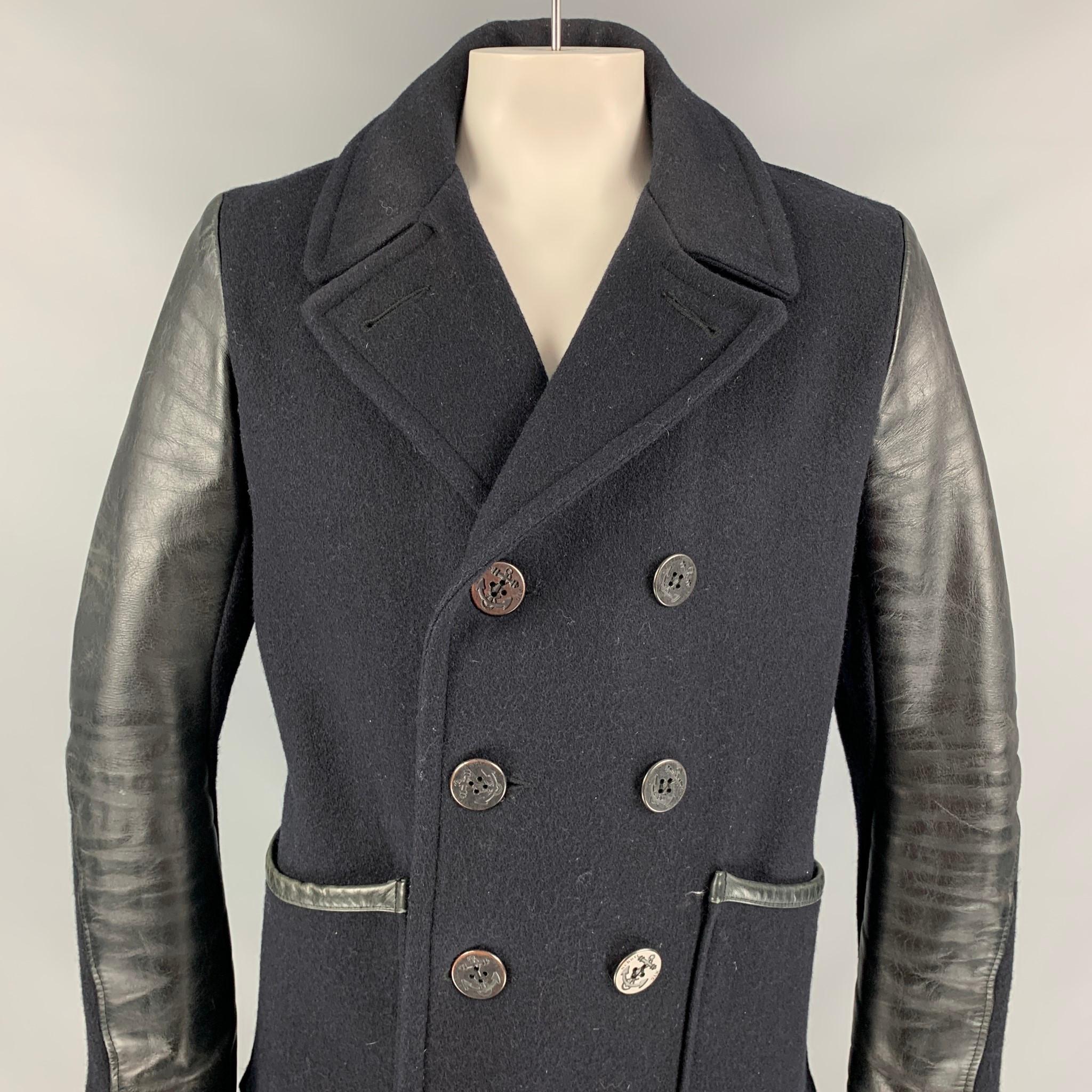 SCHOTT pea coat comes in a black material with a full liner featuring leather sleeves, patch pockets, and a double breasted closure. Made in Canada. 

Good Pre-Owned Condition.
Marked: L

Measurements:

Shoulder: 18.5 in.
Chest: 44 in.
Sleeve: 26
