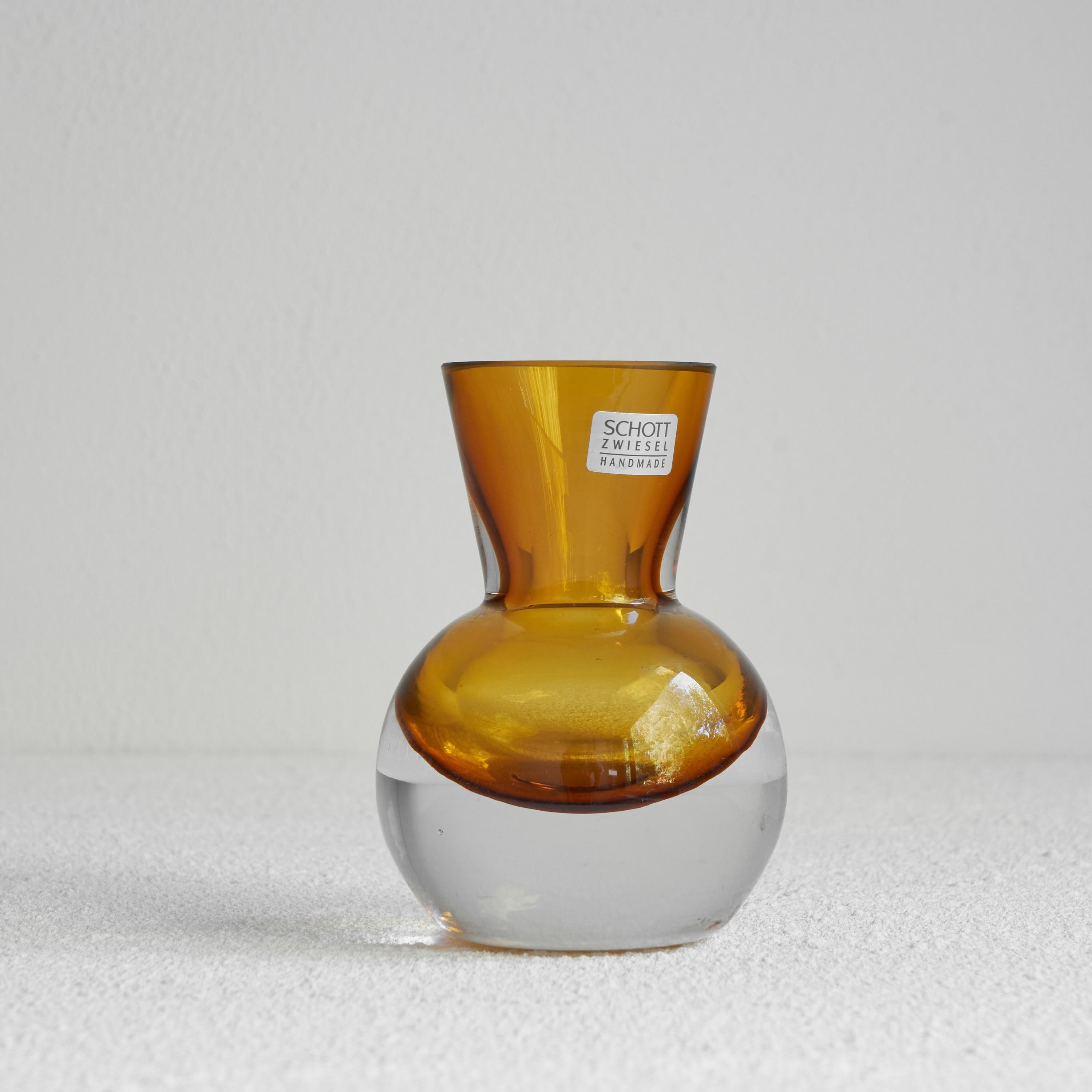 Schott Zwiesel hand blown amber colored modernist art glass vase

Beautiful modernist art glass vase by Schott Zwiesel from Germany. Made somewhere from 1960 till 1990. Great vivid amber color and a very clean and modern design with some air
