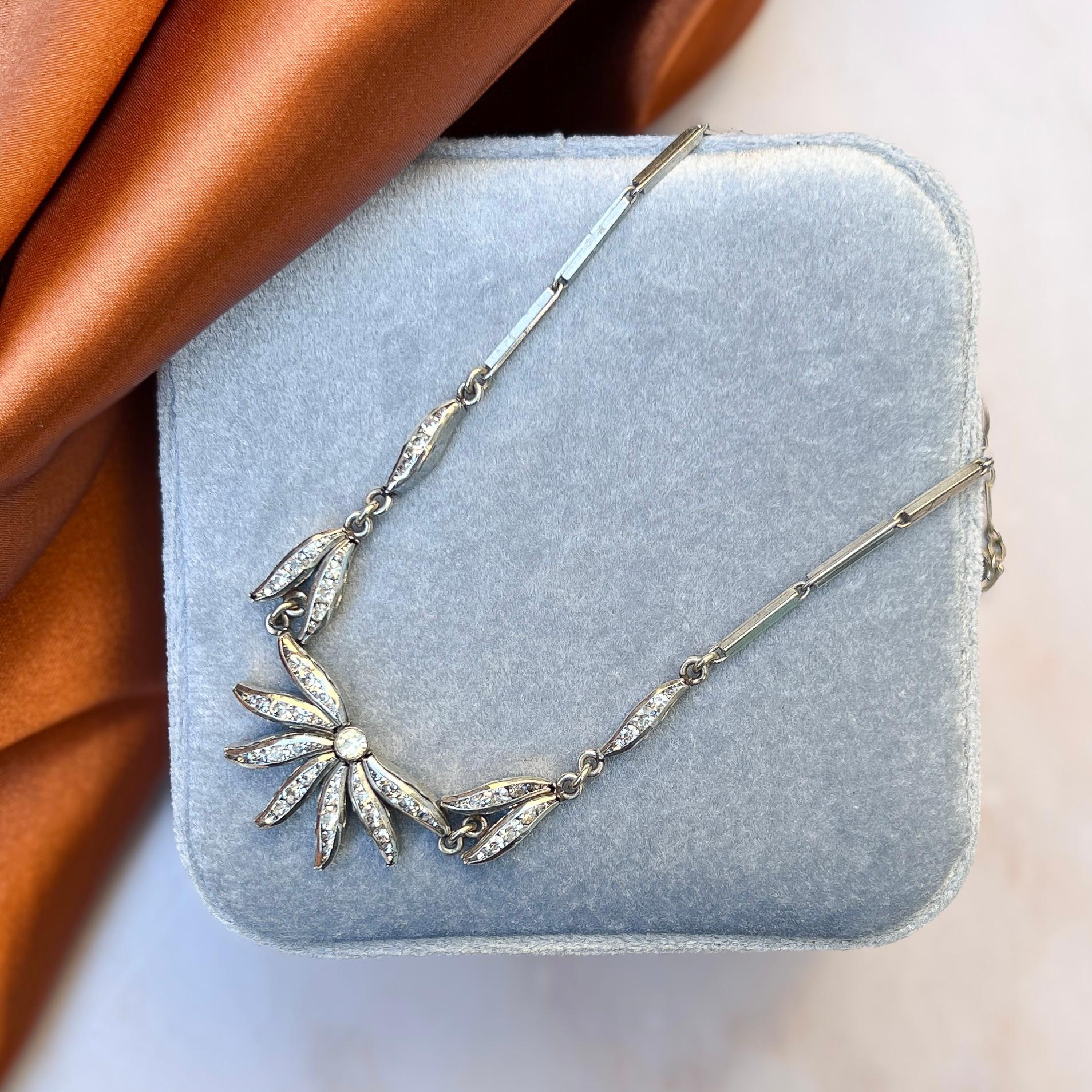 Ce joli collier date des années 1930 et a été créé en Allemagne par Schrieber et Hiller.

Rapport de condition :
Très bon - Léger assombrissement de l'une des pierres de la pâte. Ce phénomène n'est visible que sous certaines lumières et ne nuit pas