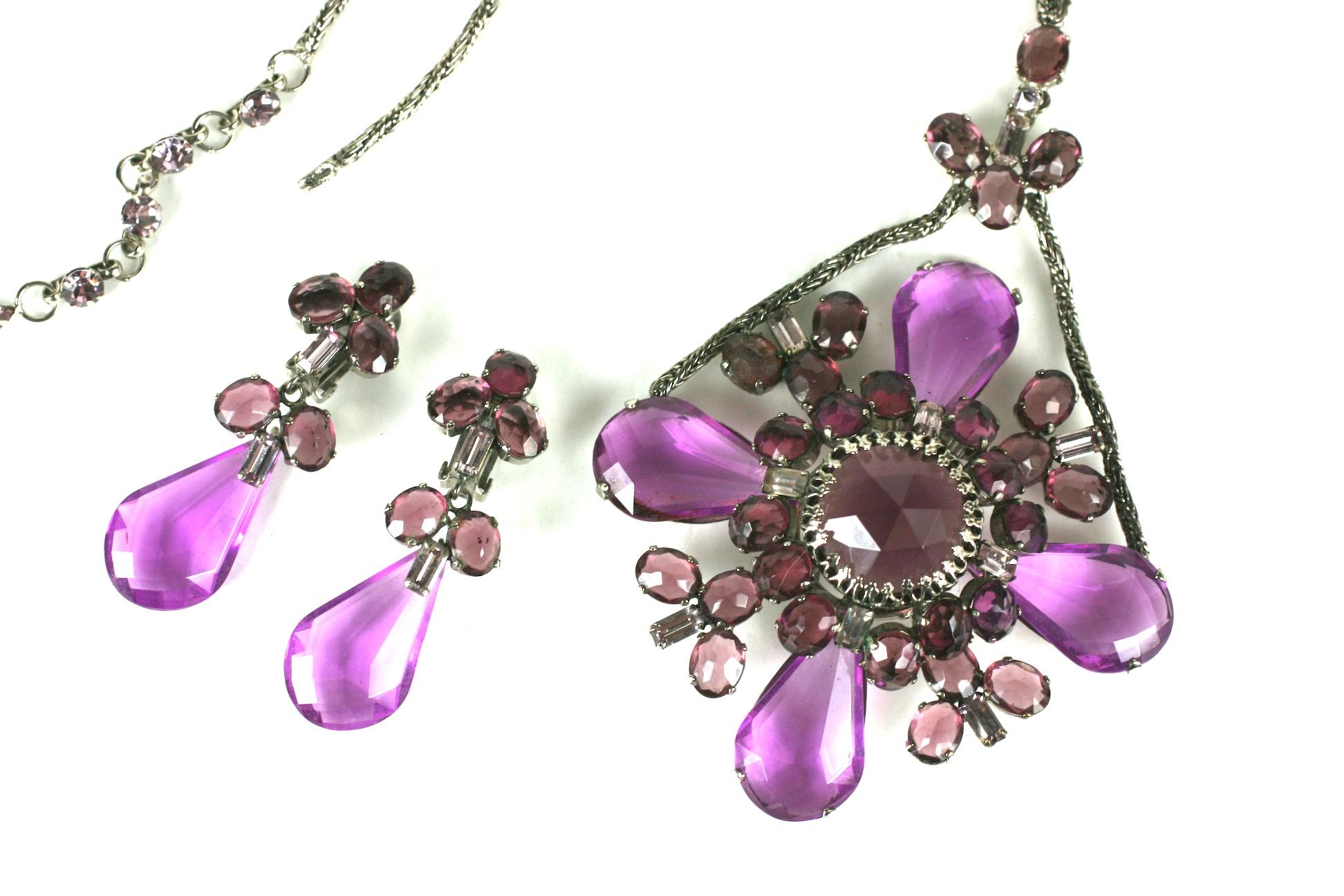 Important and impressive Schreiner Pendant Necklace and Earrings. Transformable necklace with detachable pendant which becomes a large brooch. 
2 tones of amythest lucite stones are mixed with pave baguettes throughout the suite. Signed on clip back