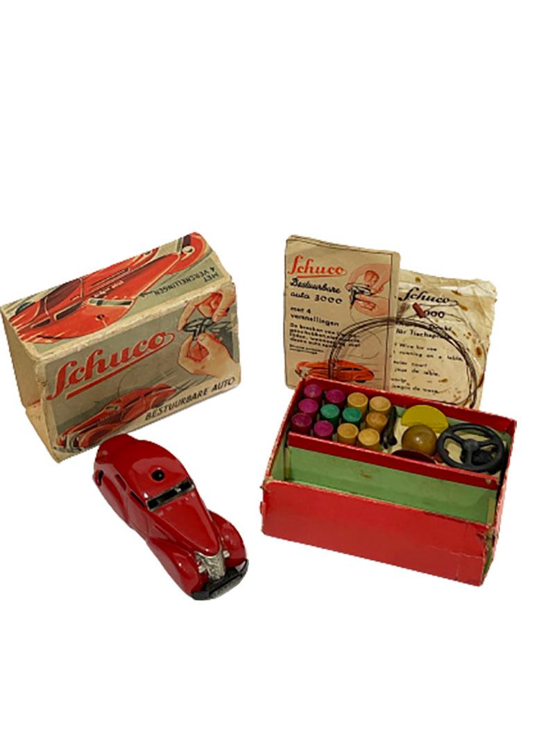 Schuco 3000 wind-up toy, Telesteering car, 1930s

A Schuco 3000 wind-up toy car in red, black and silver metal car in box with accessoires.
All original boxed Schuco with wheel, control wires, key, guide (Dutch)
It has a four speed gear and