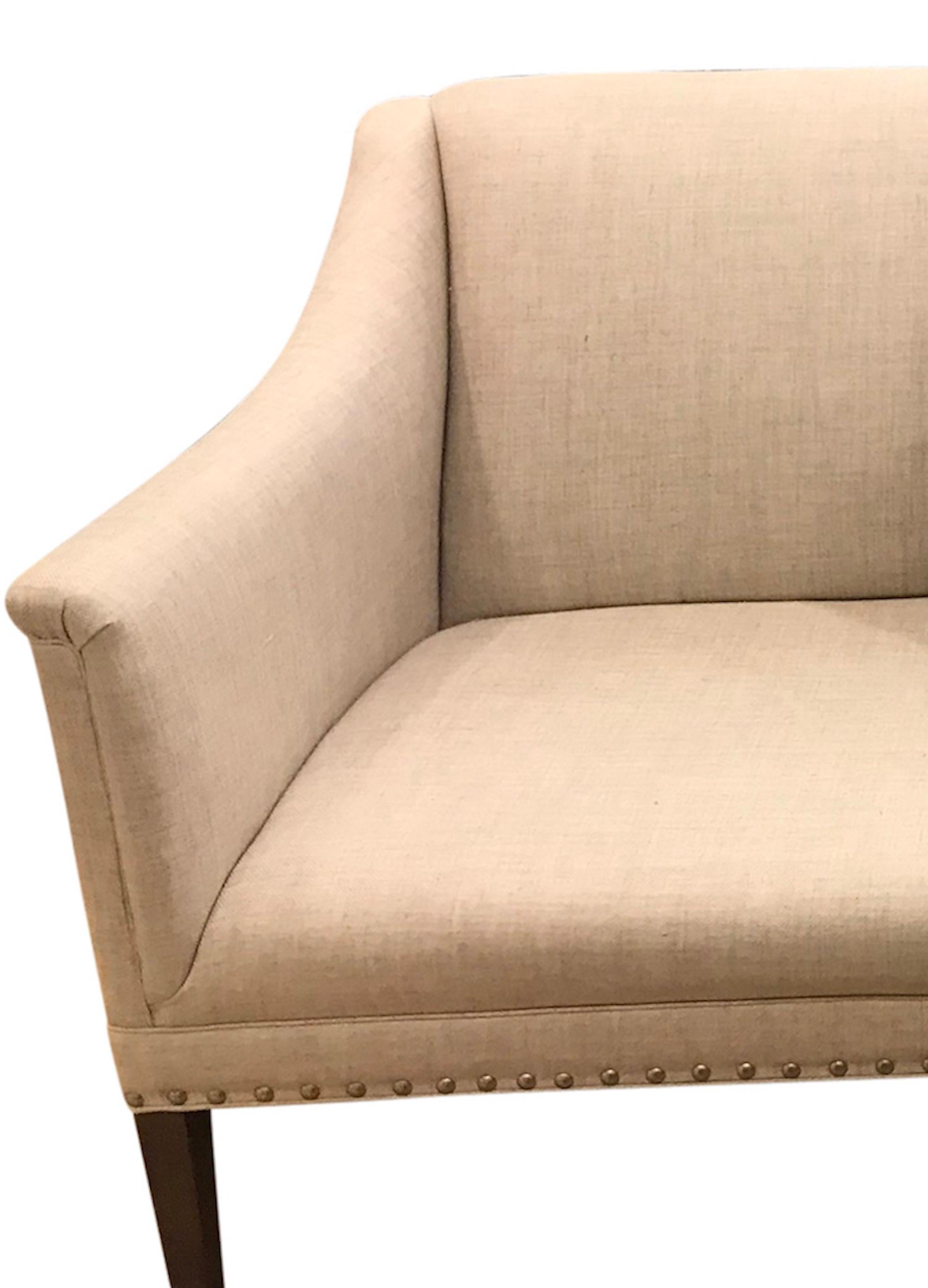 This Copenhagen sofa features a stylish silhouette with antique walnut-finished pegs. This frame is upholstered with Schumacher's classic Sahara Weave in a linen colorway, further enhancing its sleek lines.

Since Schumacher was founded in 1889,