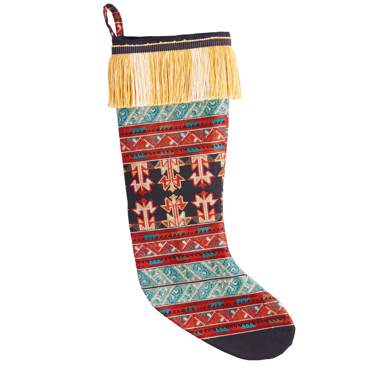 This not-quite-conventional holiday stocking is ornately embroidered with cross-stitched stripes and finished with a soft silky fringe for a limited-edition holiday stocking that feels festive and folky. Fashioned out of Schumacher’s Vinka