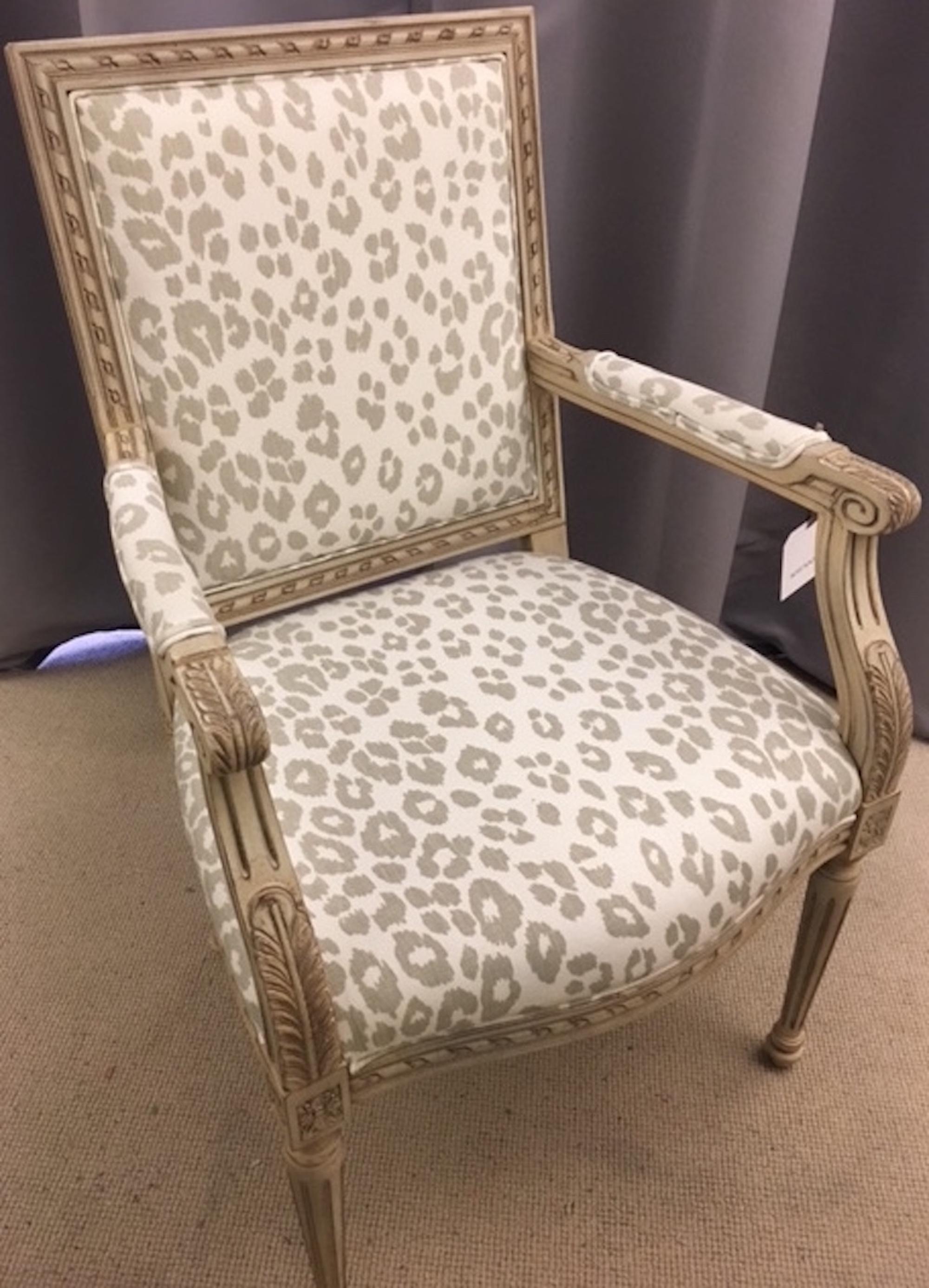 This exquisite Schumacher French Louis XVI side chair features a Classic frame, hand carved from European beechwood finished in a metropolitan grey colorway. The frame and elbow rests are both upholstered in an eternally chic Schumacher Signature
