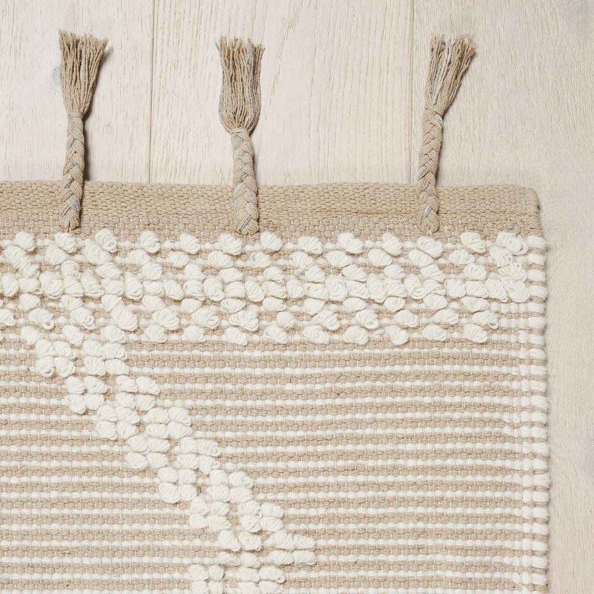 Malta French Knot ist ein dynamischer Streifen aus Wolle und Baumwolle, der auf einem traditionellen Grubenwebstuhl hergestellt wird. Er hat eine schöne Dimension und Textur, die durch Quastenfransen betont wird. Dieses vielseitige geometrische