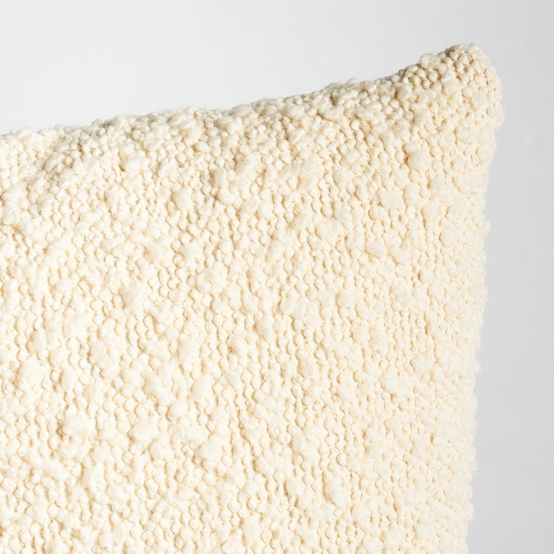 This pillow features Margarete with a Knife Edge finish. Margarete in ivory redefines bouclé. Woven with a superior yarn that blends wool and cotton with extra body and the softest finish, it results in a pillow with full-bodied loops, supreme