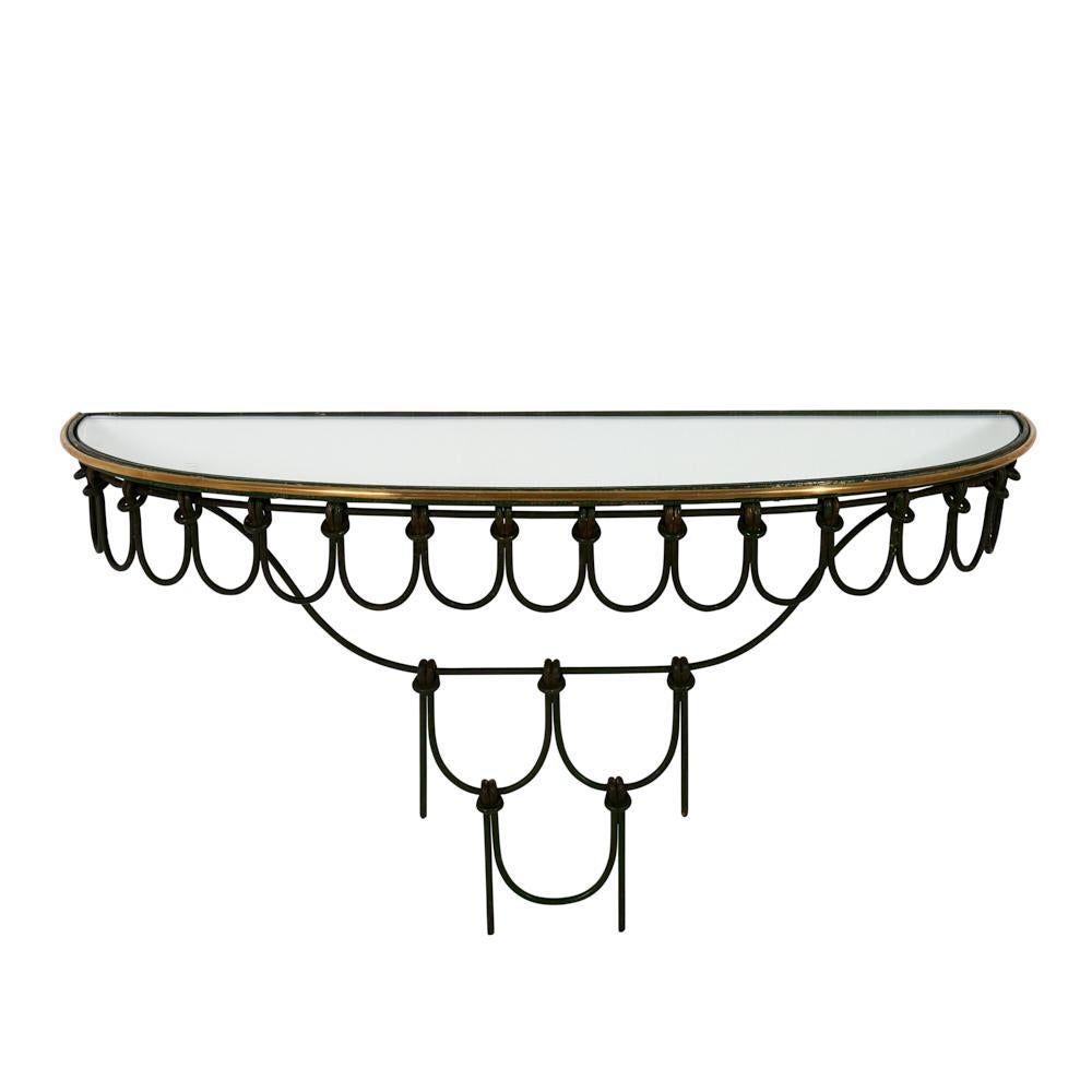 Iron doesn’t often read feminine, so this delicately done mid-century Italian mirror and console is more than a little unusual. The petite size and tiers of lace-like knots and loops make this piece truly special. The original glass has minor chips
