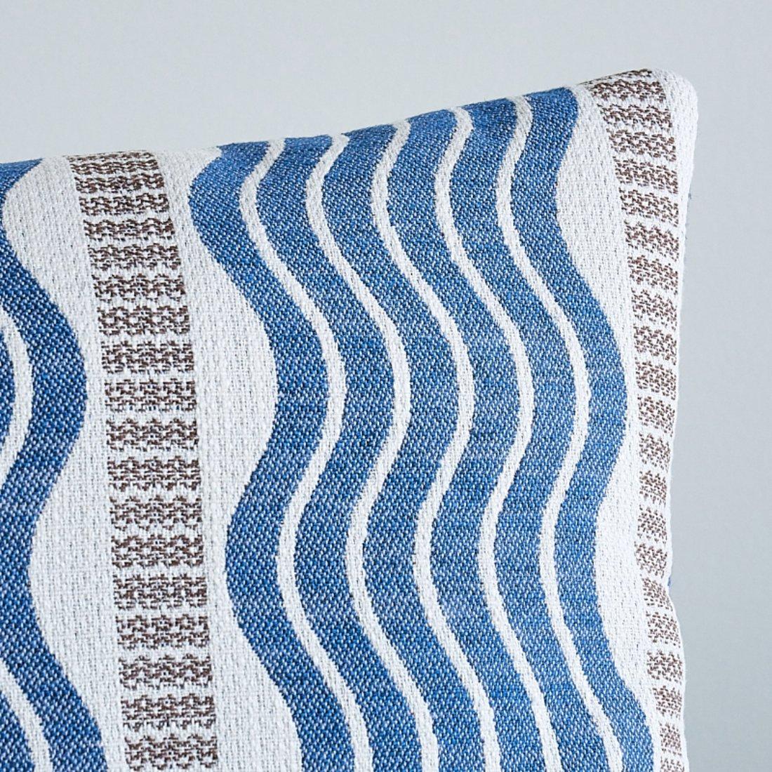 This pillow features Sina Stripe with a knife edge finish. An Art Deco treasure found in our archives, Sina Stripe in blue is a large-scale wave stripe fabric with graphic impact and a gorgeous textural weave. Pillow includes a feather/down fill