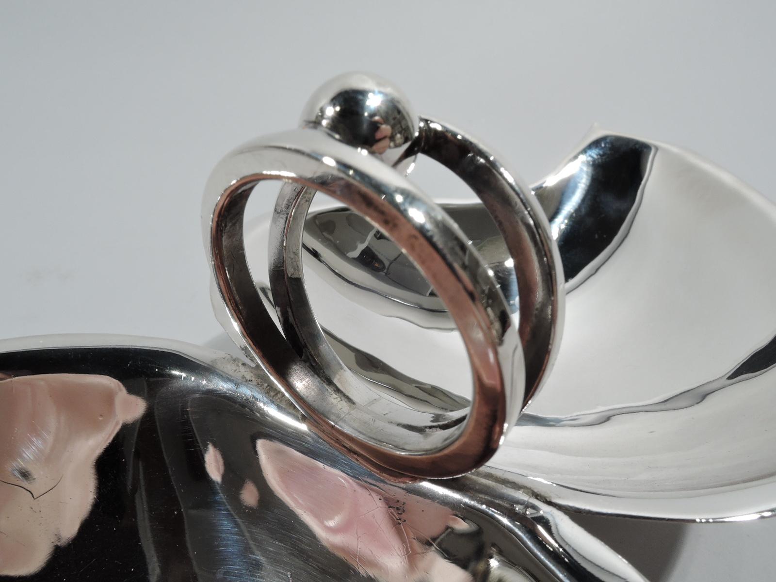 Mid-Century Modern sterling silver condiment dish. Made by Alfredo Sciarrotta in Newport. Two leaf-bowls joined by two rings inset with ball. Rests on 4 balls. Postwar informality wrought in precious metal. Fully marked including maker’s stamp, no.