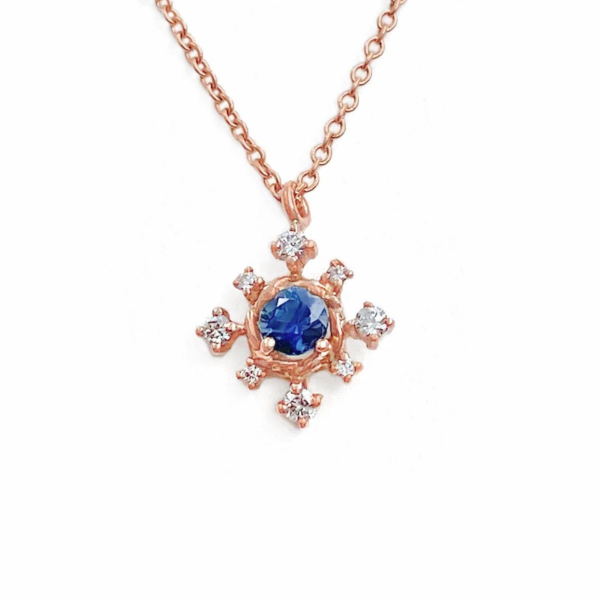 Dainty and exquisite Scilla blue sapphire and diamond star drop pendant necklace, showcasing a prong set 3.5mm round medium blue sapphire supported by JeweLyrie signature twist base that’s surrounded with 8 prong set 1.5mm and 1mm brilliant cut