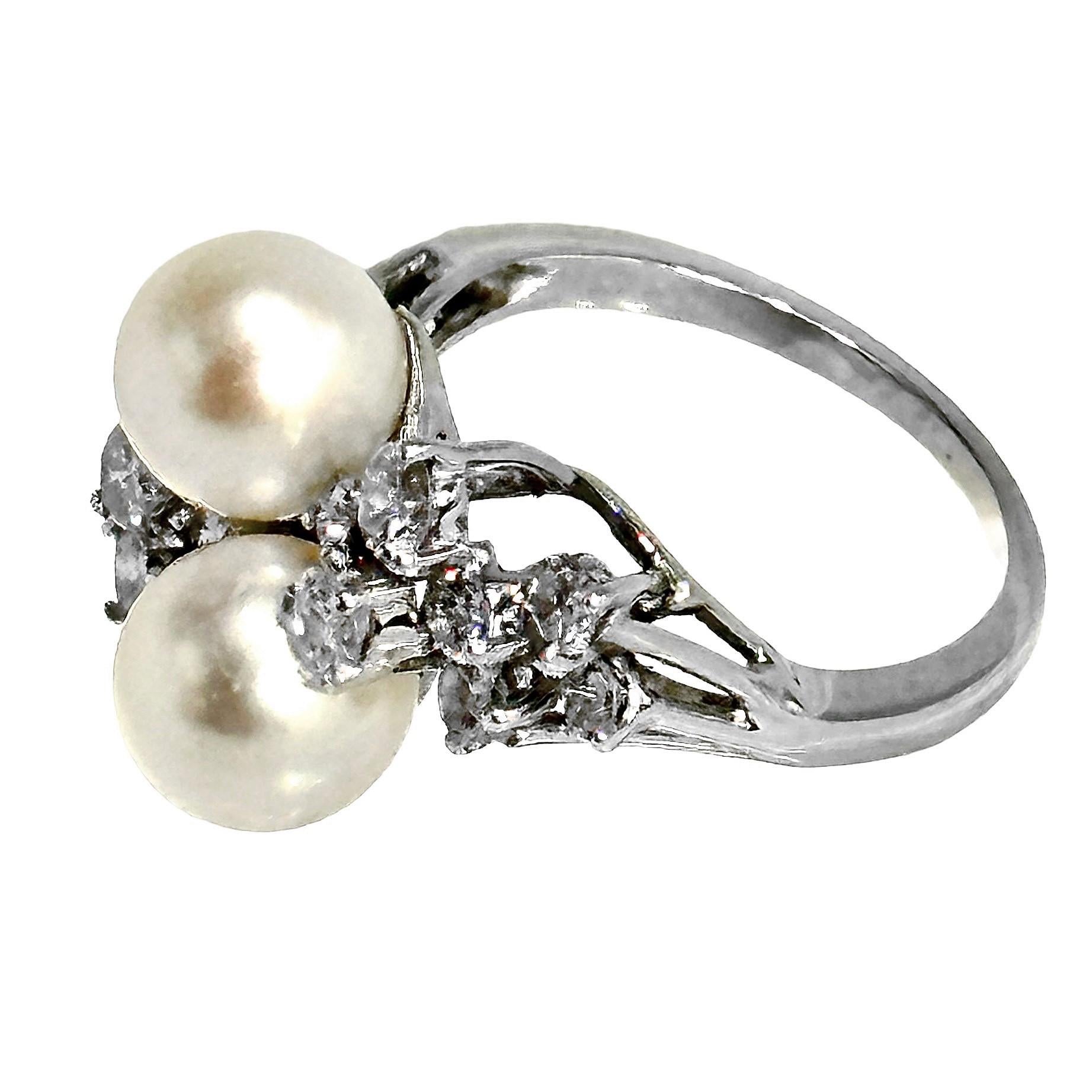 This lovely and glittering 18K white gold cocktail ring epitomizes Mid-20th Century jewelry design. Two high quality 8mm Japanese Akoya saltwater cultured pearls are nestled between a total of fourteen brilliant cut diamonds which have a 1.25CT