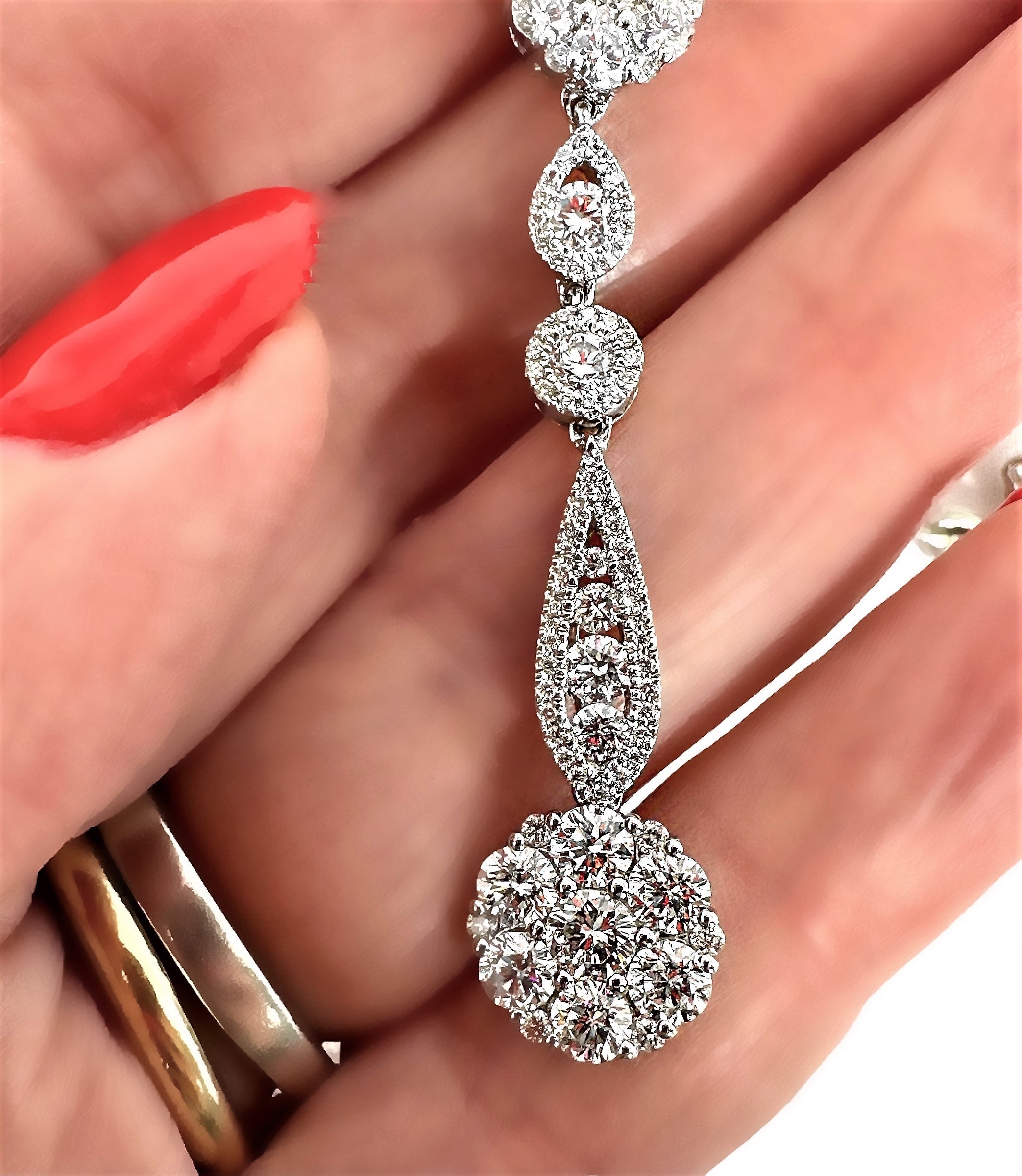 This modern design 18K white gold and diamond necklace absolutely shimmers and scintillates. The necklace measures 18 inches in length, and from the center hangs a 1 5/8 inch diamond encrusted drop. Crafted in a heavy and durable 18K white gold