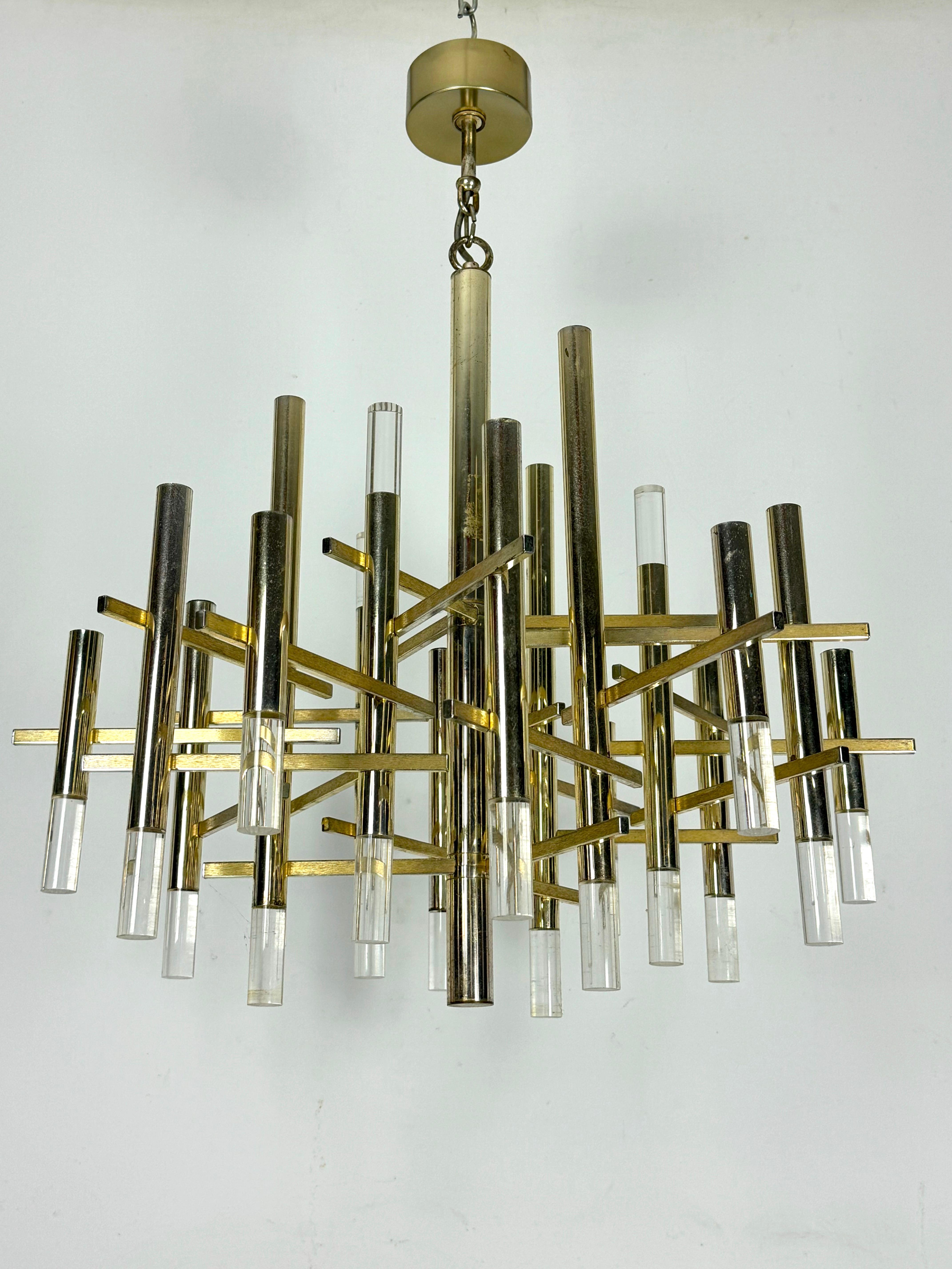 Produit en Italie dans les années 60 par Sciolari, il est en bon état avec des traces d'âge et d'utilisation. Fabriqué en chrome doré et en plexiglas, il comporte 15 douilles pour ampoules E14. Hauteur du luminaire sans tige 65 cm. Fonctionne
