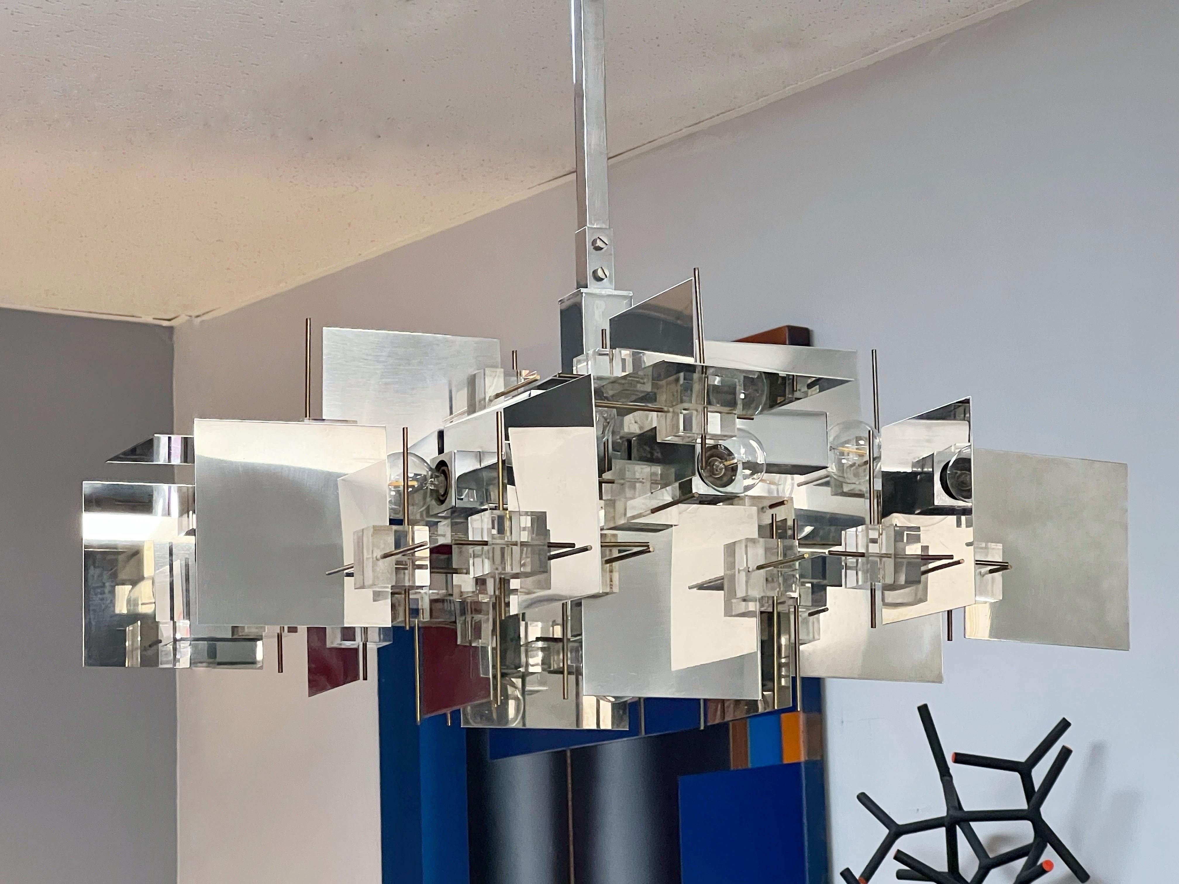 Iconic Sciolari chandelier. Polished stainless steel squares are interlocked with lucite cubes and brass rods to create the interesting multi plane design. Retains the original and versatile hanging hardware, the chain and/or square rod can be