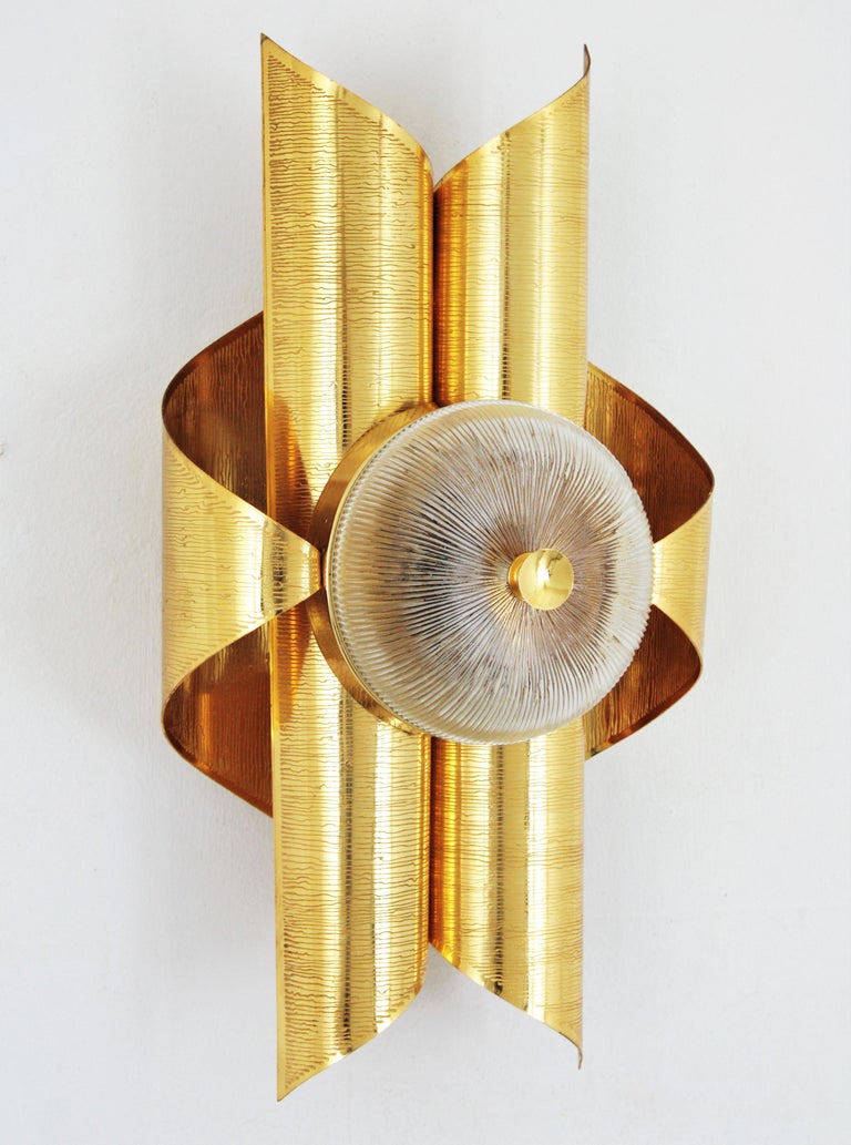 Sciolari Inspired Italian Modernist Gold-Plated Brass and Glass Wall Sconce. Italy, 1960-1970.
A beautiful gold-plated brass and glass scroll shaped wall sconce with a circular glass shade, 
This wall lights is symmetric in design, the brass is