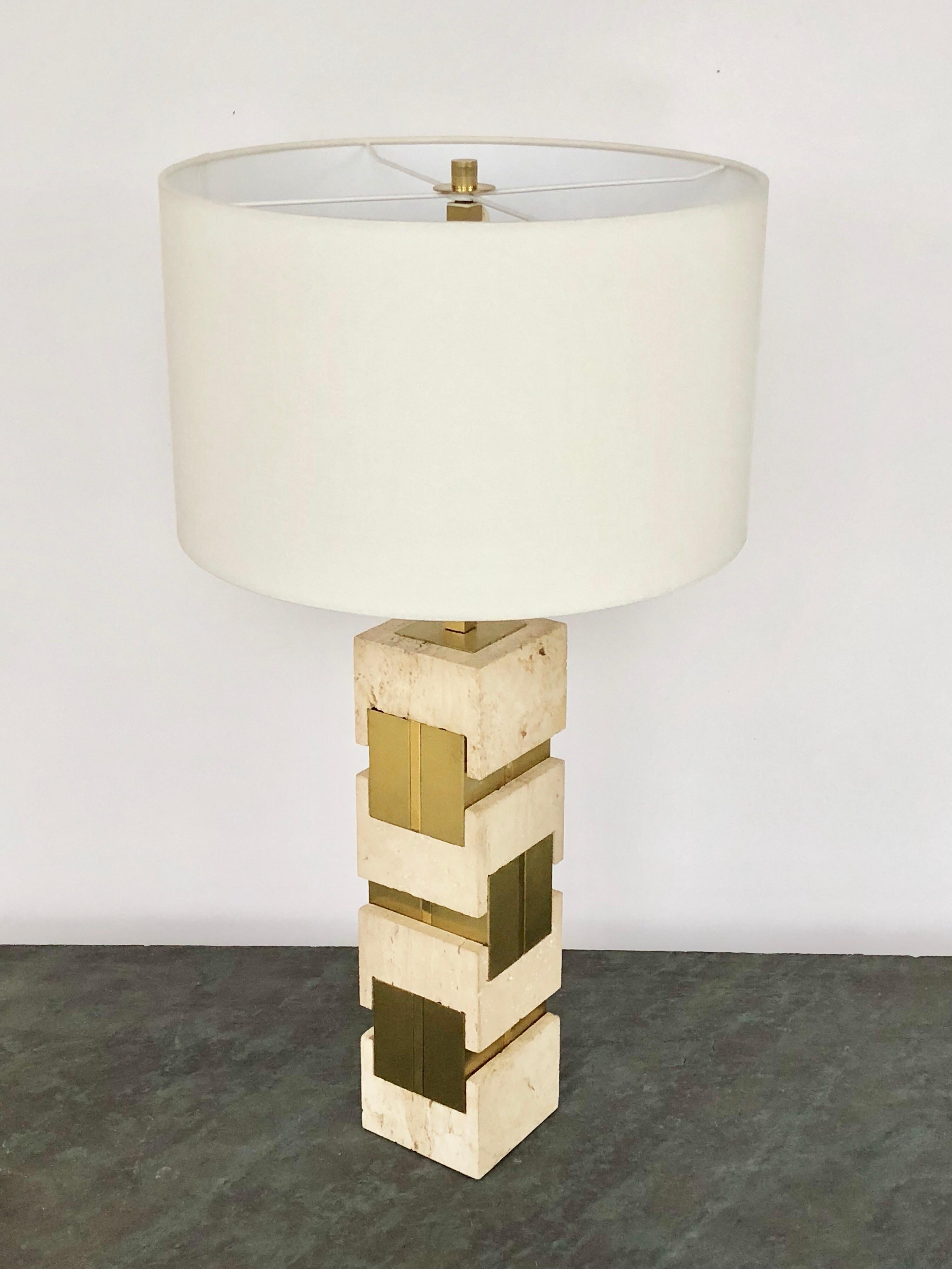 A large travertine marble and brass table lamp by Gaetano Sciolari. Retains the original square shade. The marble pieces interlock with the brass elements and create a look reminiscent of jewelry. Retains original square shade and finial. Signed on