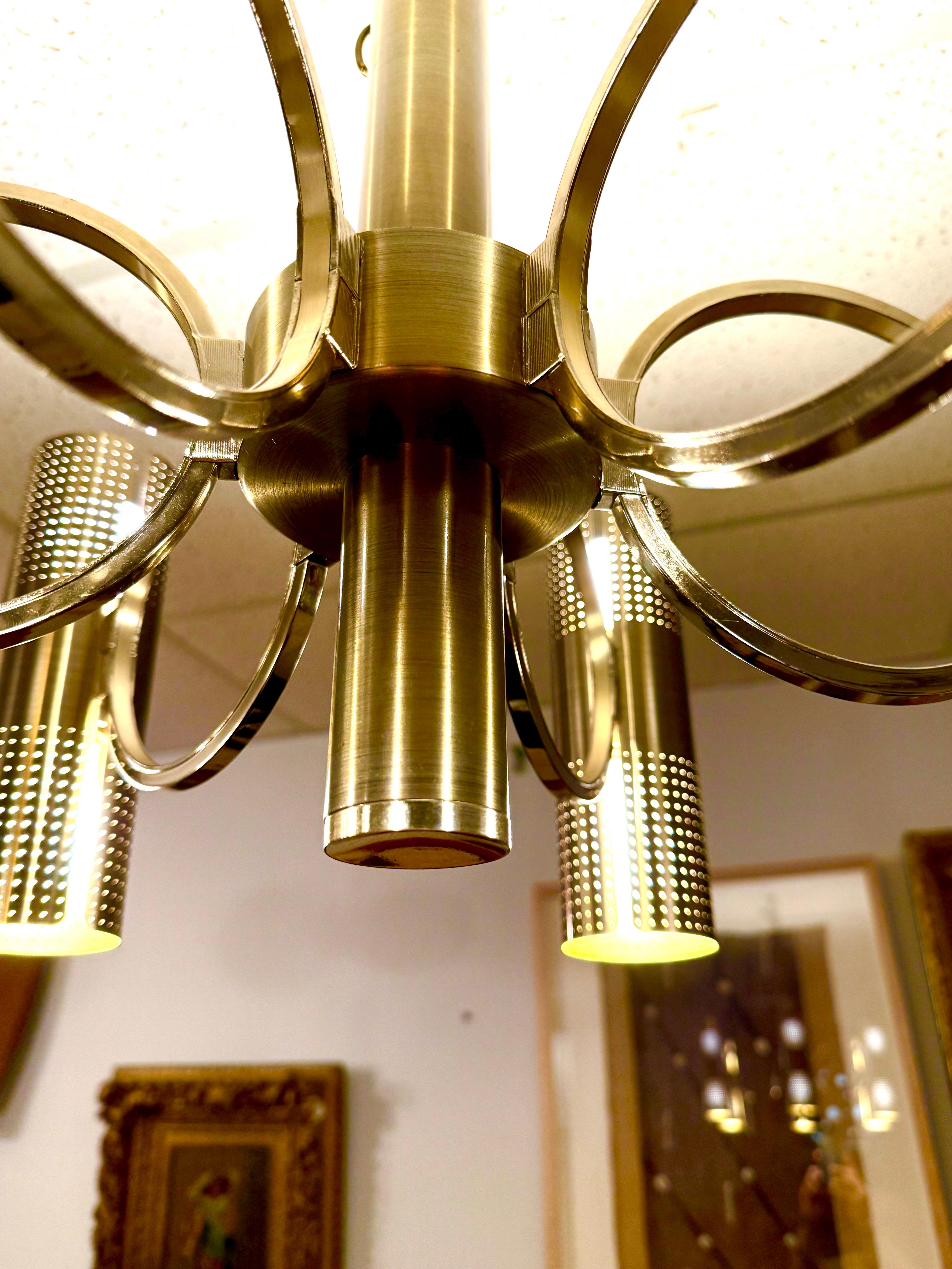 Magnificent 12-light chandelier with cylindrical perforated brass arms.  Each arm is circular leading to the cylinder adorned with pinholes providing soft ambient light.  Matte finish brass perforated cylinders with two lights each on Six (6) arms.