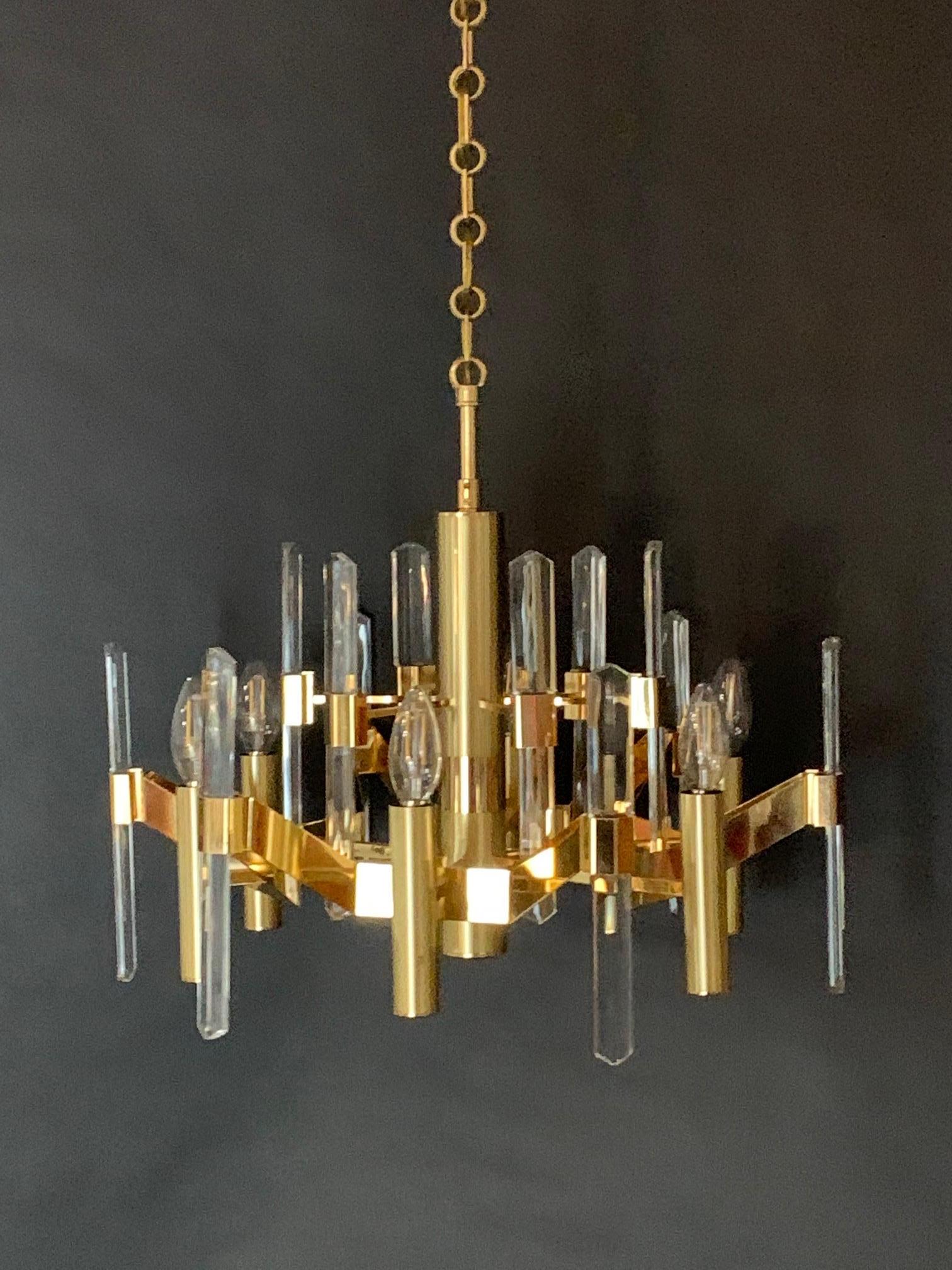 Lustre Sciolari en laiton à six lumières avec des éclats de cristal optique. Un design moderniste qui combine des surfaces en métal et en verre pour créer de la profondeur et de l'illusion.
  