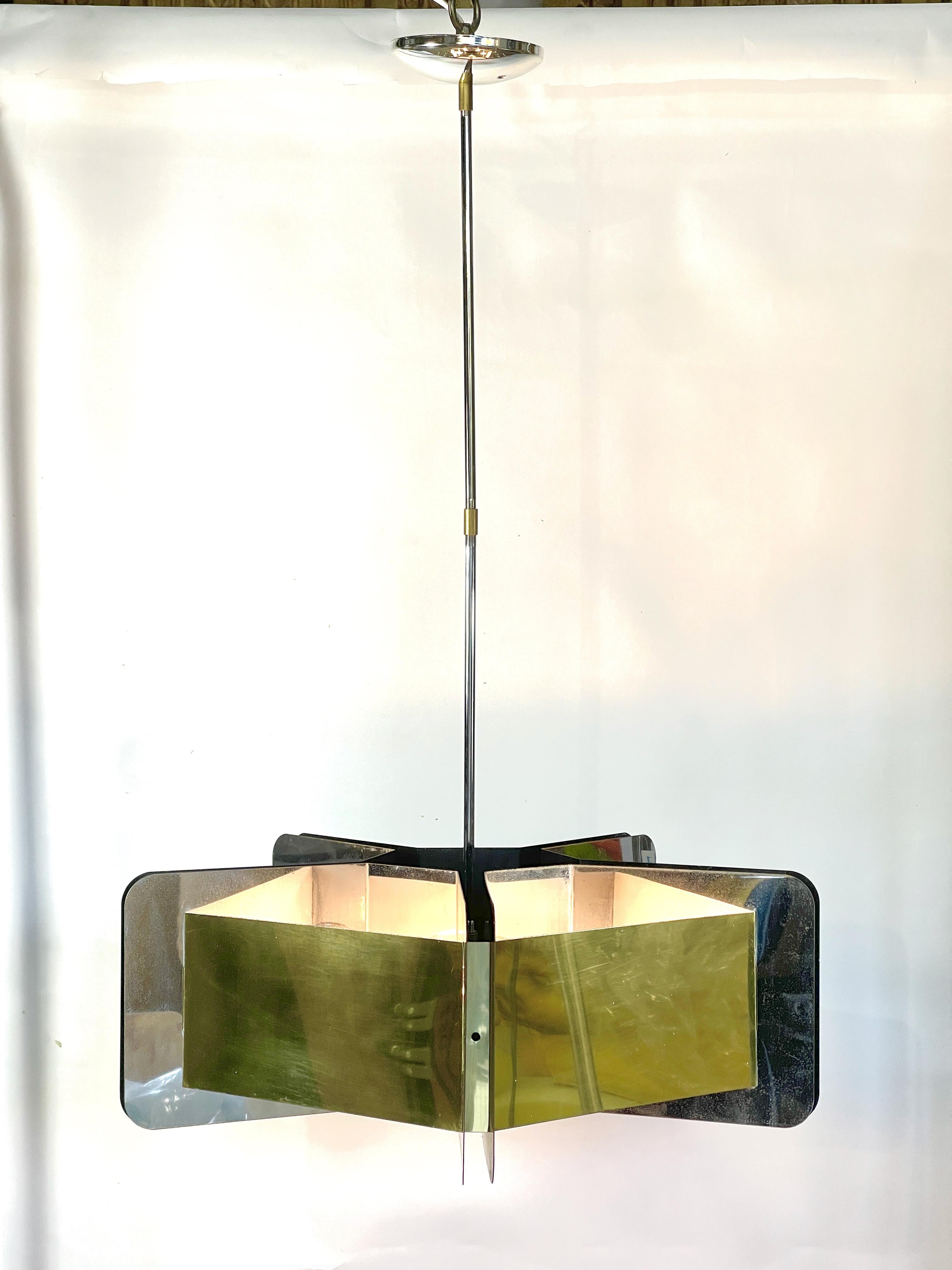 Vintage 1970's pentagonal form chandelier in the style of Gaetano Sciolari made from formed mirror polished stainless steel sheet and brass, probably manufactured by Fredrick Ramond of California.
Five porcelain edison screw sockets. Original