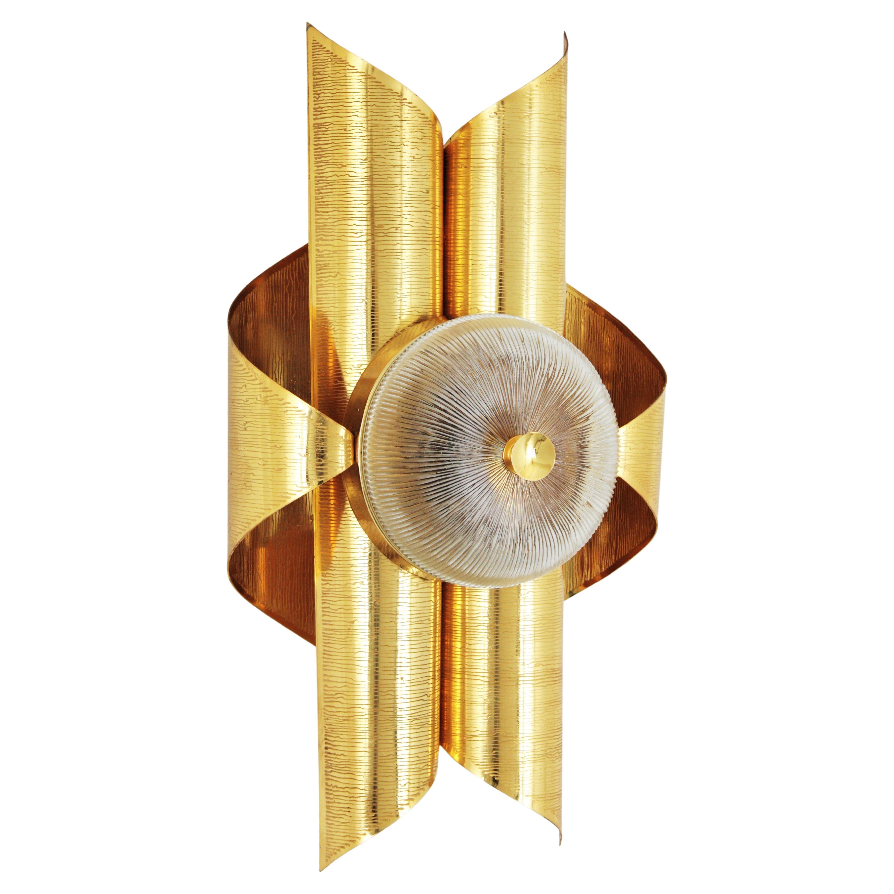 Applique da parete in ottone placcato oro e vetro di ispirazione italiana Sciolari. Italia, 1960-1970.
Una bellissima applique a forma di voluta in ottone placcato oro e vetro con paralume circolare in vetro, 
Questa lampada da parete ha un design