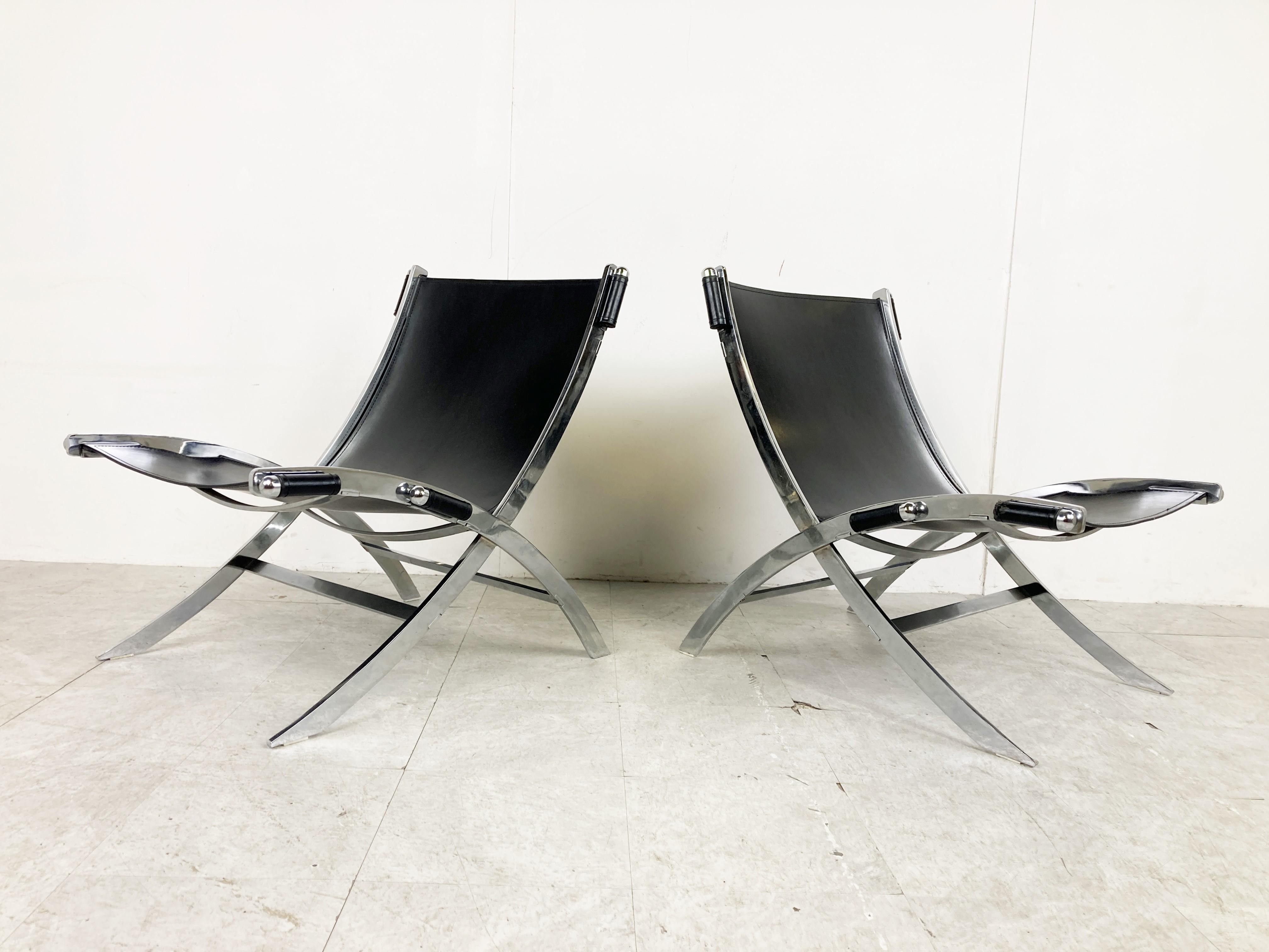 Pair of black leather lounge chairs designed by Paul Tuttle and Antonio Citterio and produced by Flexform in the 1980s.

Elegant scissor shaped chromed steel based and sling leather seats/backrests.

Good overall condition with normal age