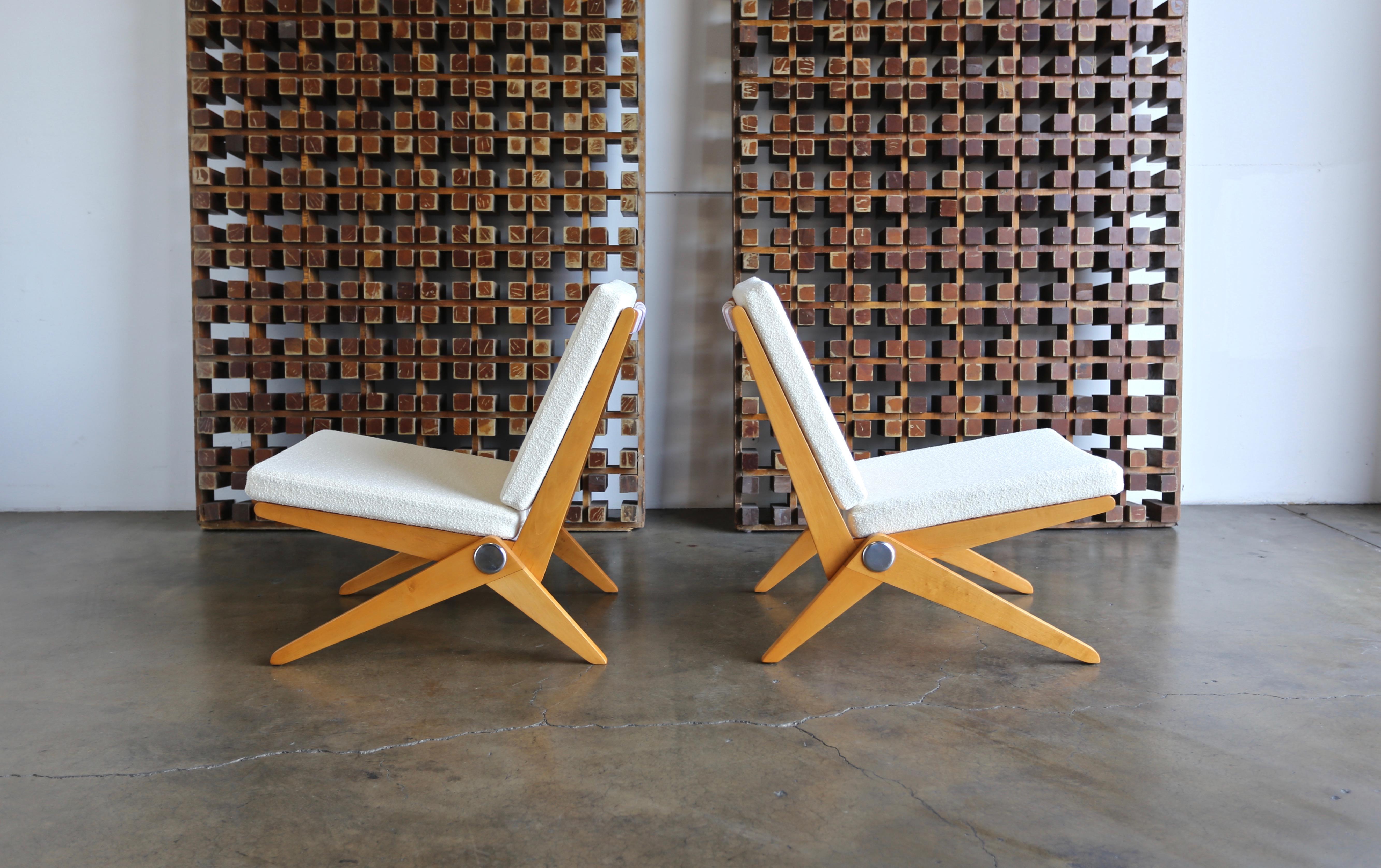 Pair of Scissor lounge chairs by Pierre Jeanneret for Knoll International, circa 1955. This pair has been professionally restored. New Knoll white bouclé upholstery.