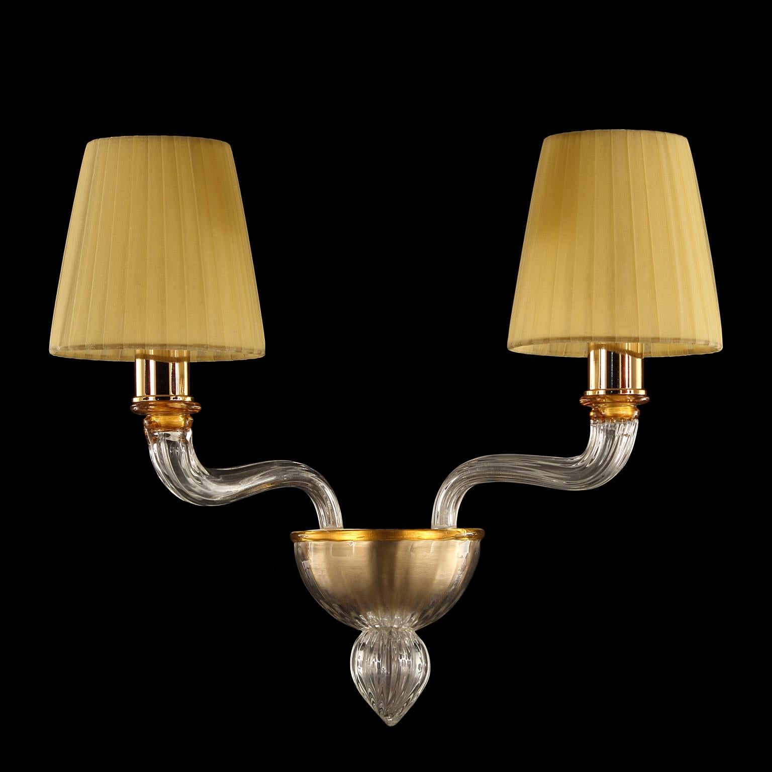 Coco sconce with 2 arms in clear and amber Murano glass with amber colour handmade lampshades by Multiforme.
The Murano glass Coco collection takes inspiration from Coco Chanel, the revolutionary woman that has changed the fashion industry during