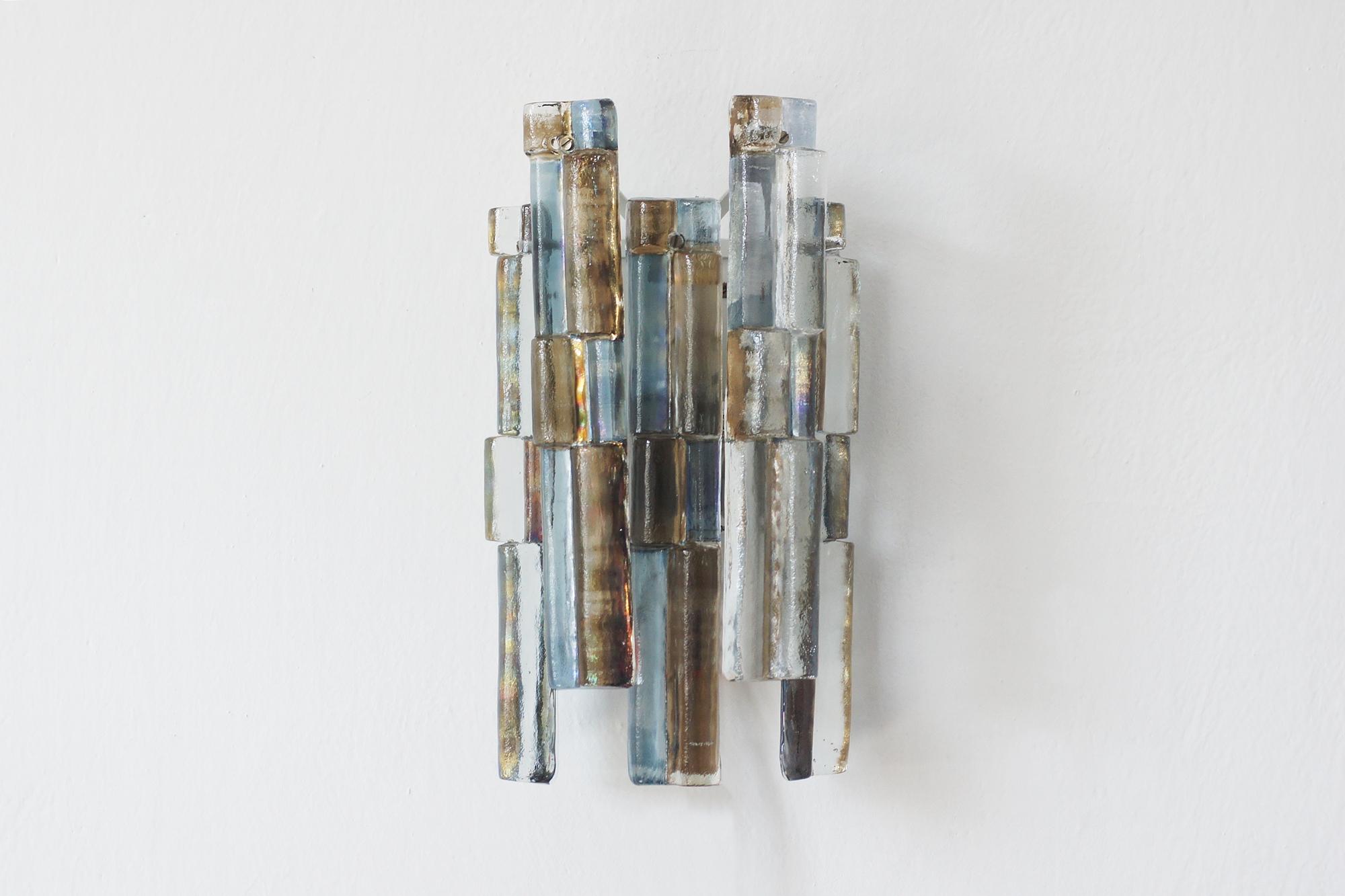 A unique wall sconce designed by Julius Theodor Kalmar for the renowned Kalmar Werkstätten. The model with colored glassbardo rarely seen.
It is a classic of Austrian design of the mid-20th century - elegant, timeless and perfectly in line with the