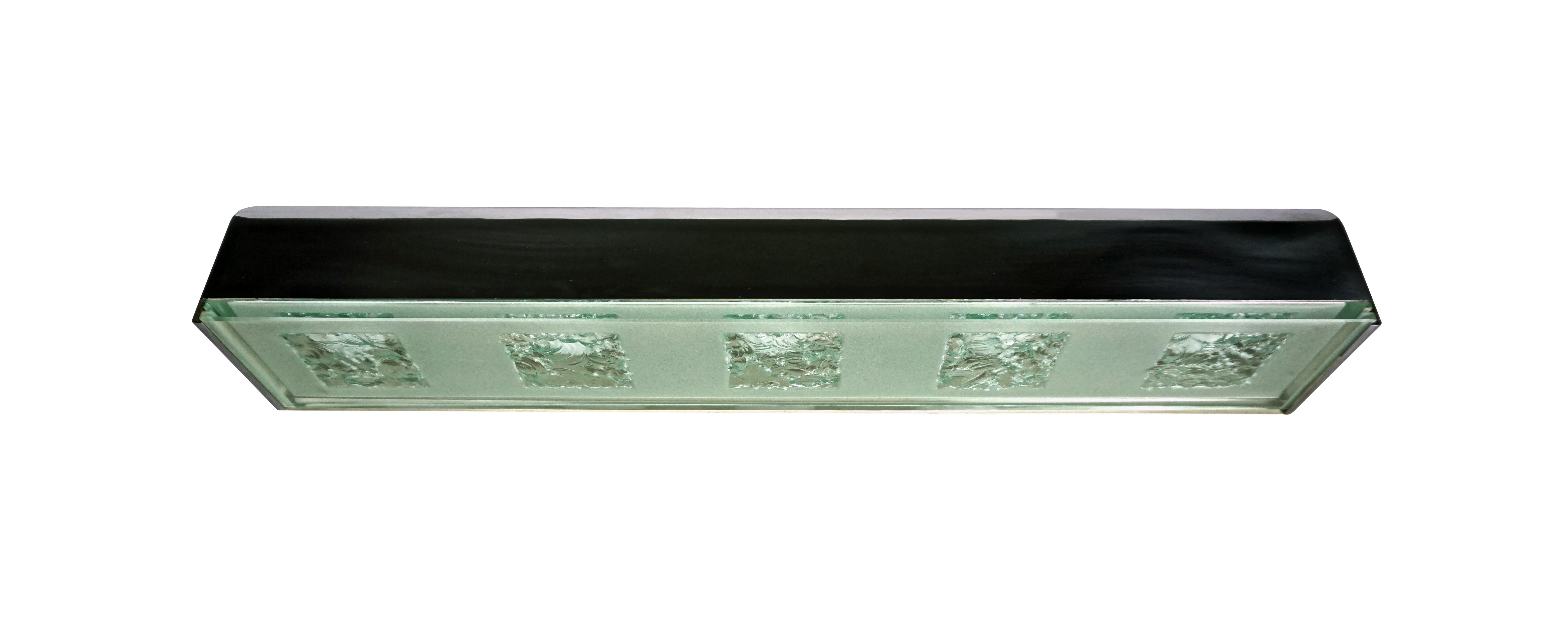 This partially opaque glass panel has five hand-chiseled squares. This panel slides onto the nickel plated brass lamp unit by slim tracks incised into the end edges.
-Produced by Fontana Arte in Italy
-Glass and nickel plated