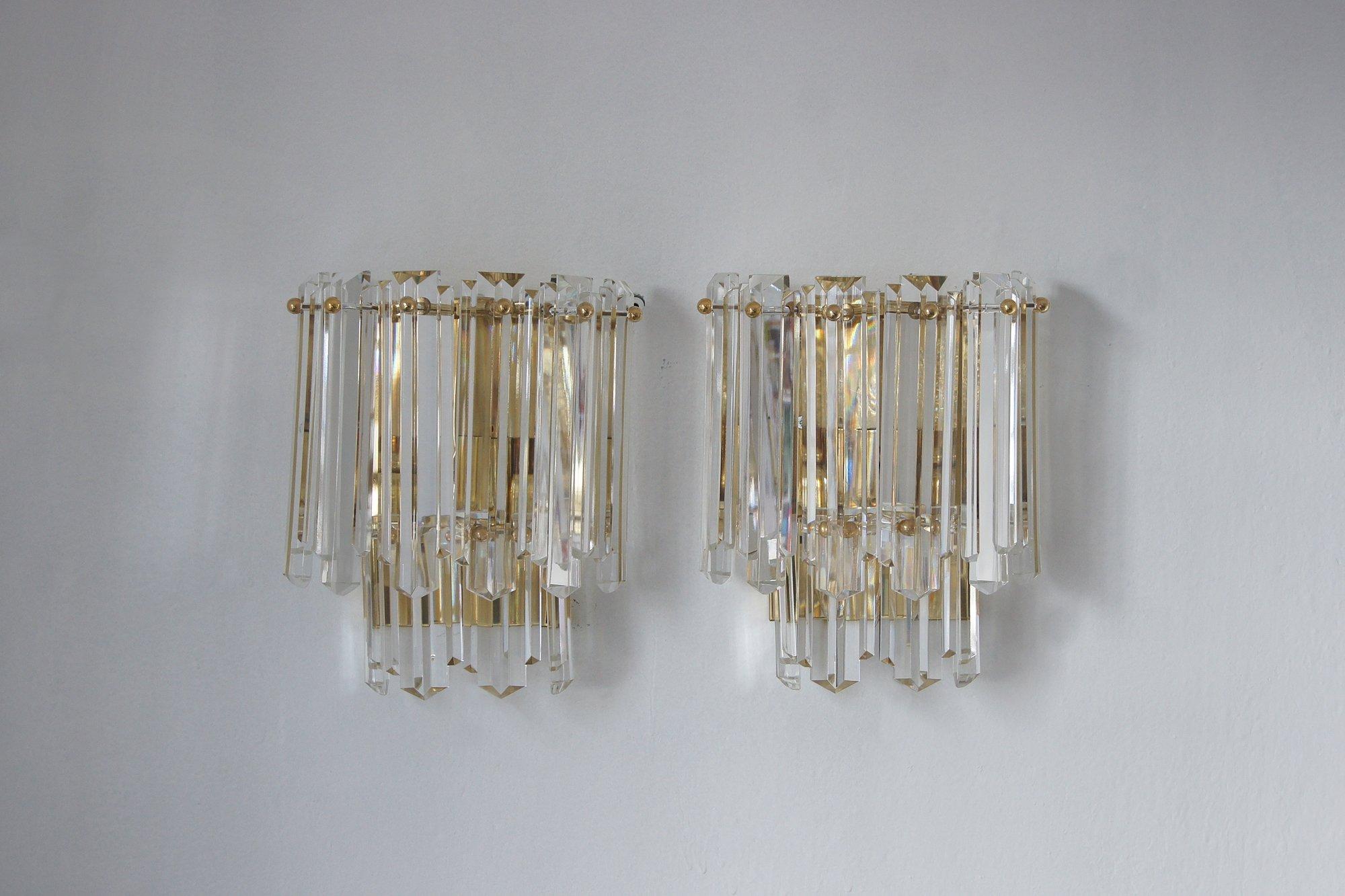 The wall lamp set is one of the rare models created by J.T. Kalmar in the 1970s.
The wall lamp has ten panels made of relief crystal glass, all mounted on a metal frame in gold color , powered by three E14 bulbs.

In excellent original