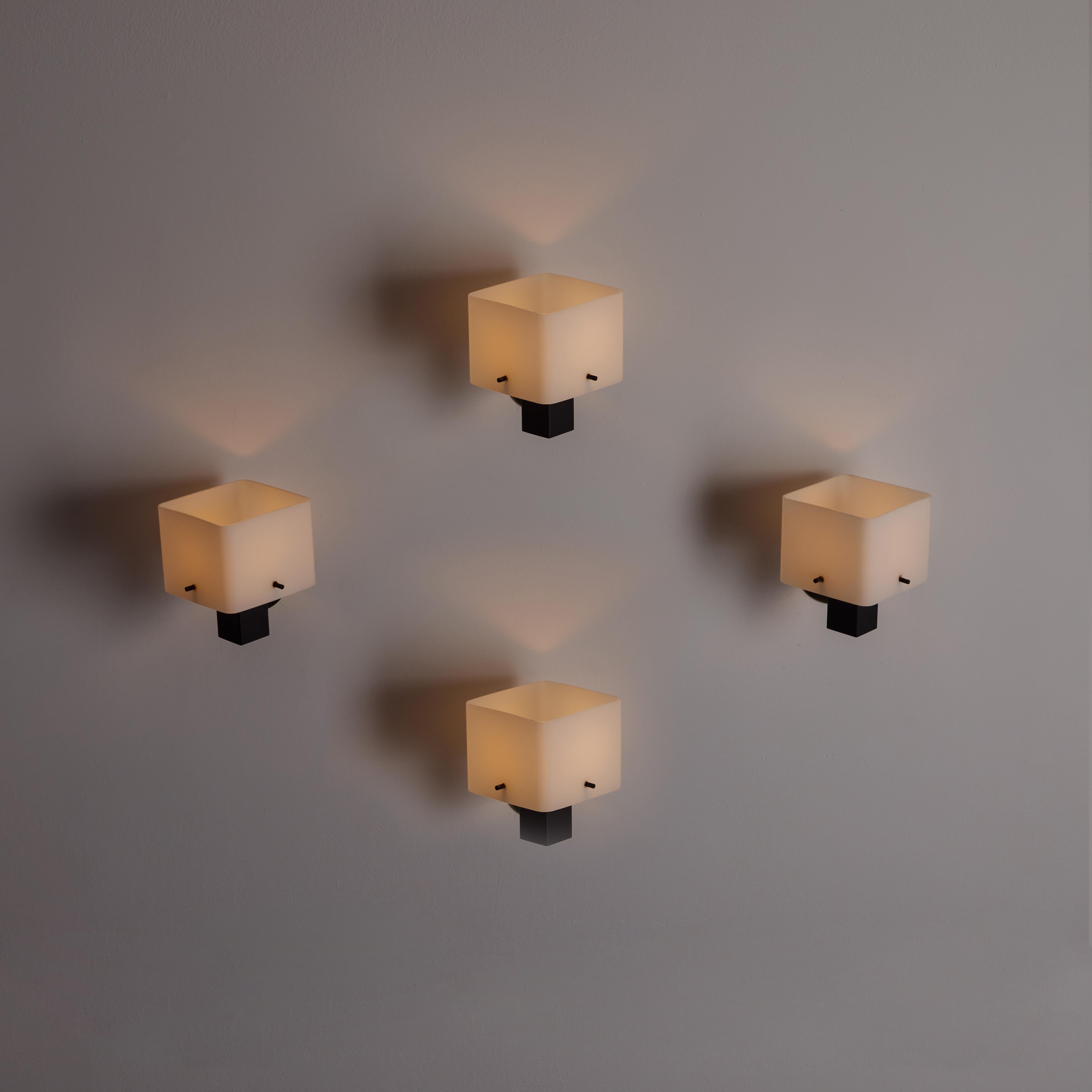 Two Sconces by Stilux. Designed and manufactured in Italy, circa the 1950s. A square opal glass diffuser is staked into an enameled armature with brass accents. Each sconce has a single E27 socket type, adapted for the US. We recommend a single