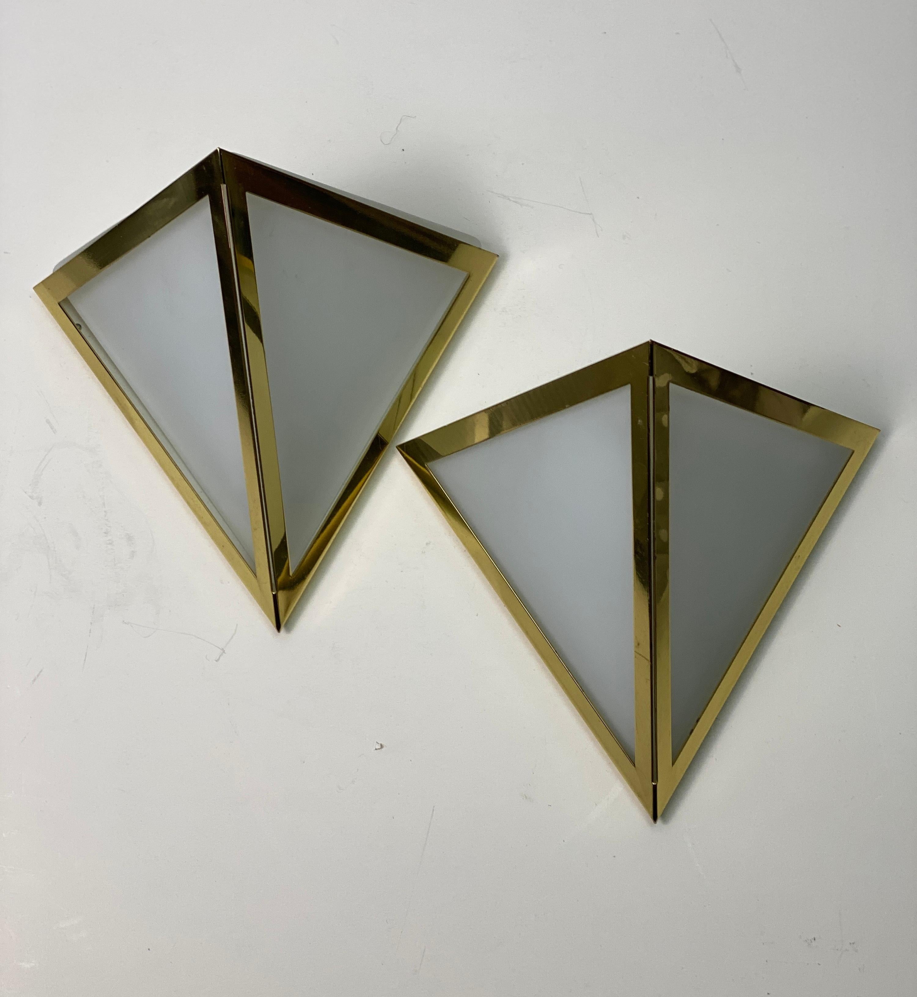 Very elegant and characteristic set of brass and opal glass Sconces produced in Germany by Glashütte Limburg in the 1980s. Each lamp has a very solid triangle opal glass base surrounded with a handsome brass triangle frame. In very good and original