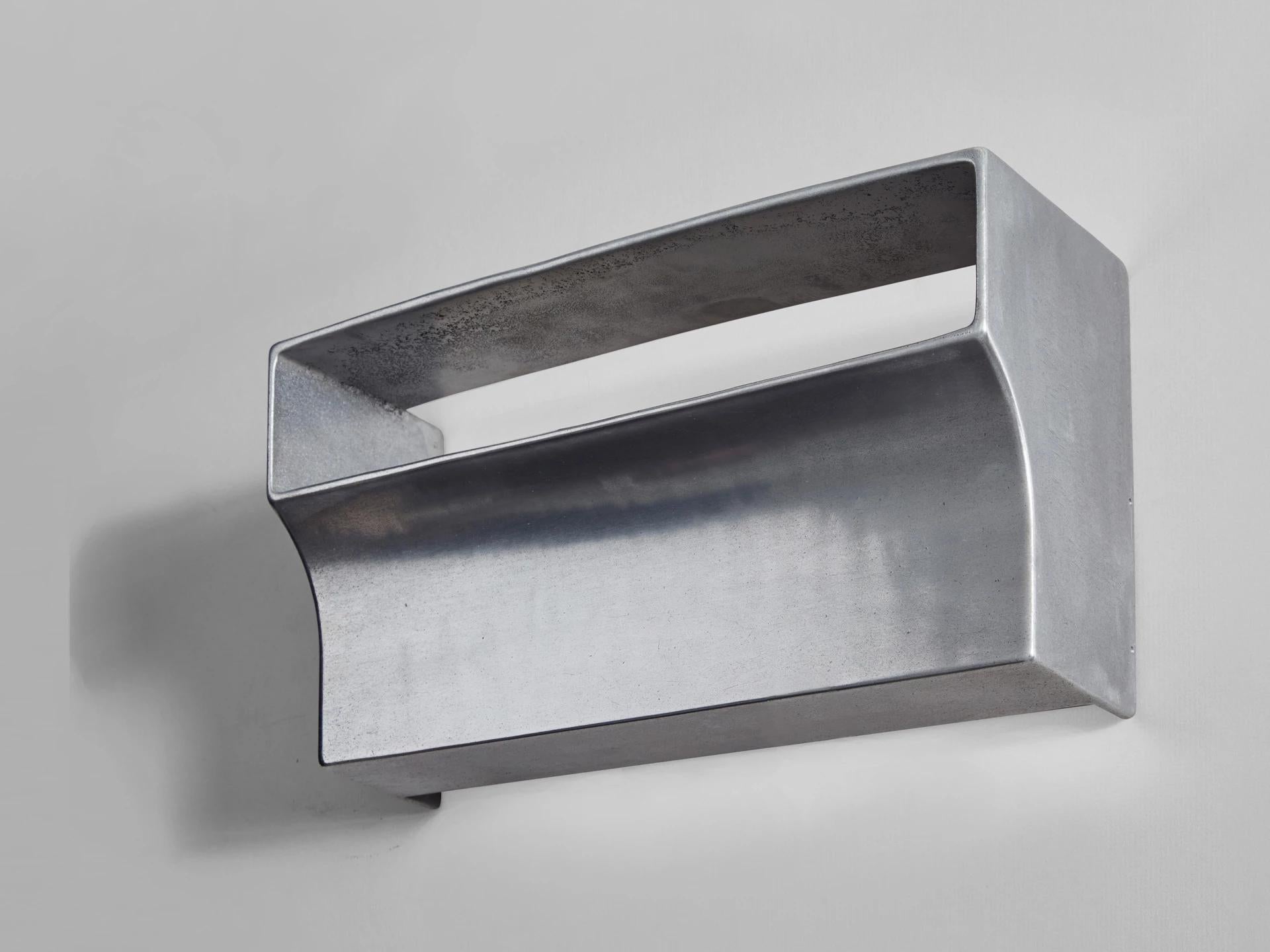 Scoop aluminium wall light by Henry Wilson
Scoop wall light is sand cast in aluminium. Openings on the top and bottom of the sconce allow light to wash up and down the walls, while the slot at the front projects light outwards while hiding the bulbs