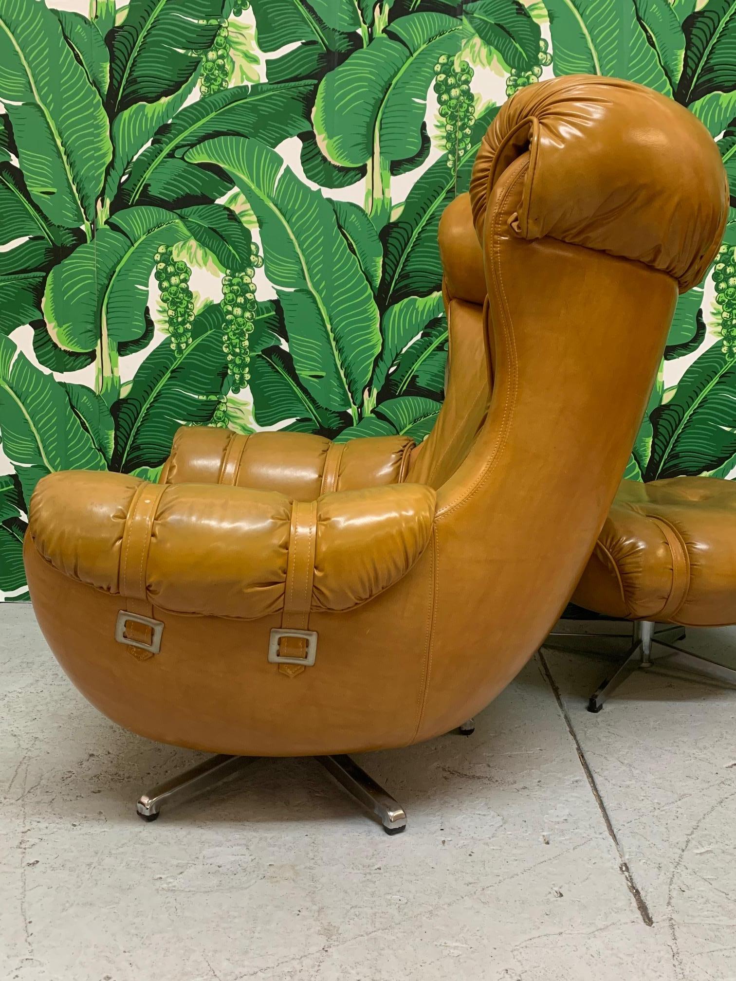 Vintage chair and ottoman by Carter Chair Corp. in the style of Overman. Soft, supple vinyl and swivel bases on both. Very good condition with only minor imperfections consistent with age.