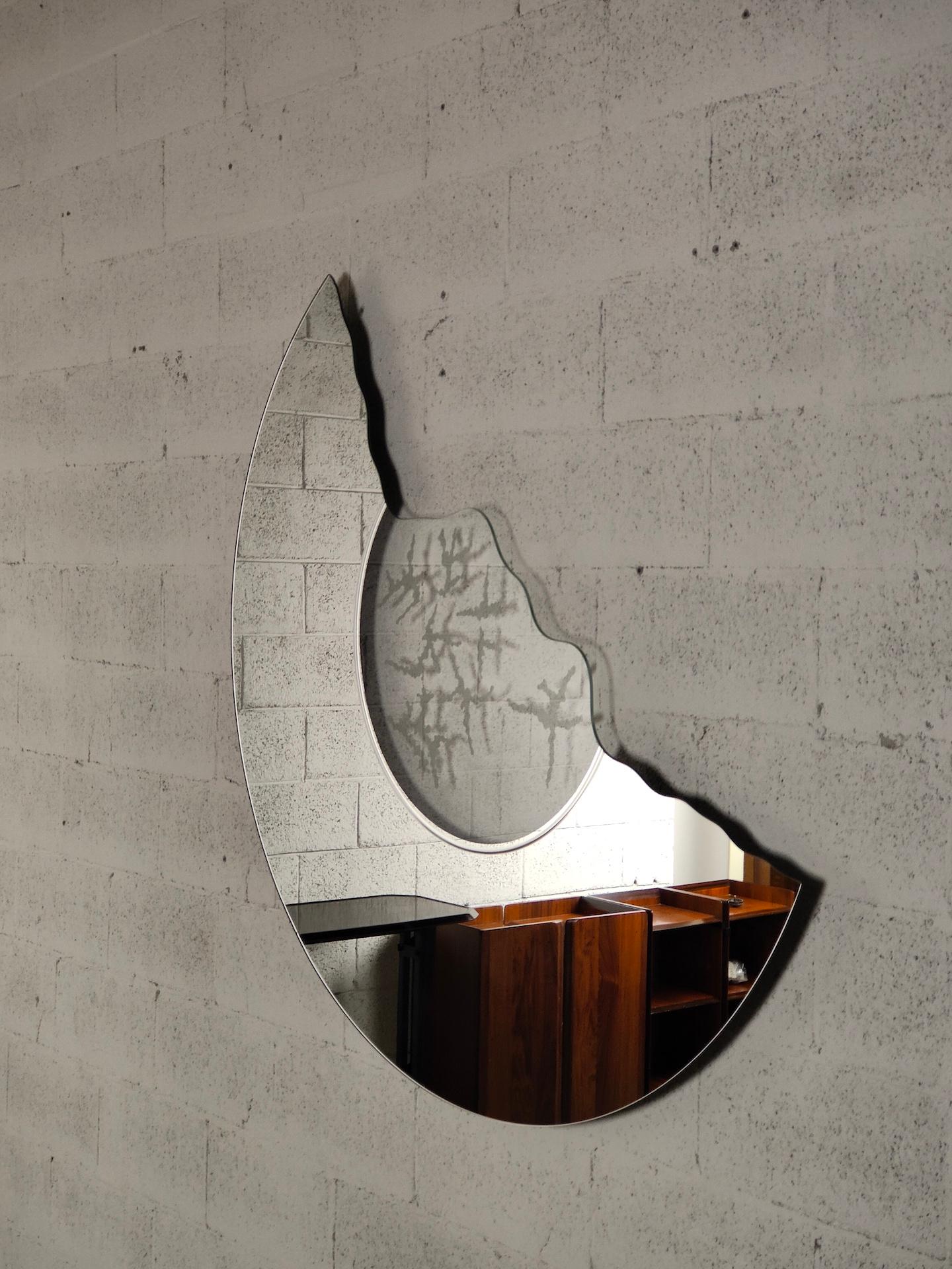 Der von Nanda Vigo für Glas Italia entworfene Spiegel Scornice ist eine Serie von Spiegeln mit Rahmenmotiven und satinierten Verzierungen auf der transparenten Oberfläche, die die Reflexionen des Glases wiederholen.

Fernanda Enrica Leonia Vigo,