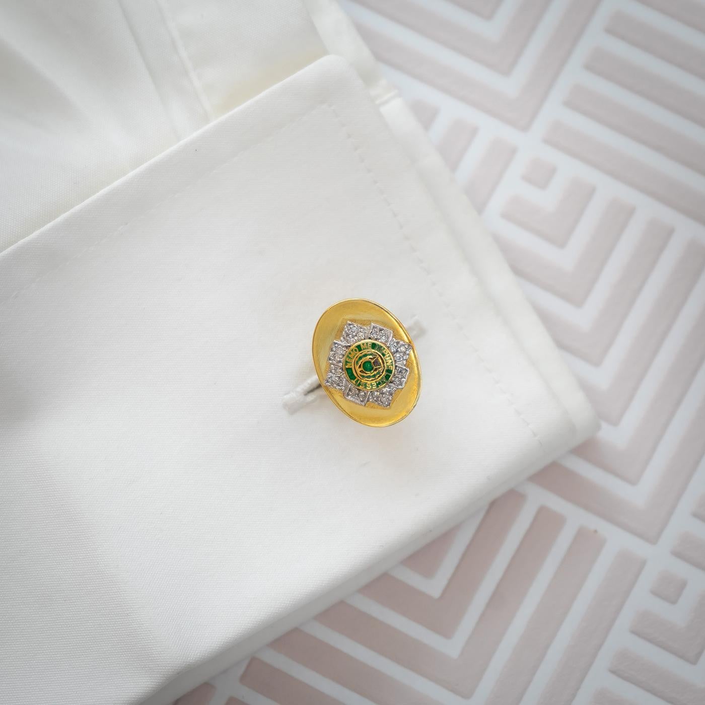 A pair of Scots Guards Cufflinks, with green enamel, bearing the motto nemo me impune lacessit, no one provokes me with impunity, surround by eight-cut diamonds in white gold settings, mounted on yellow gold oval plates, with bar