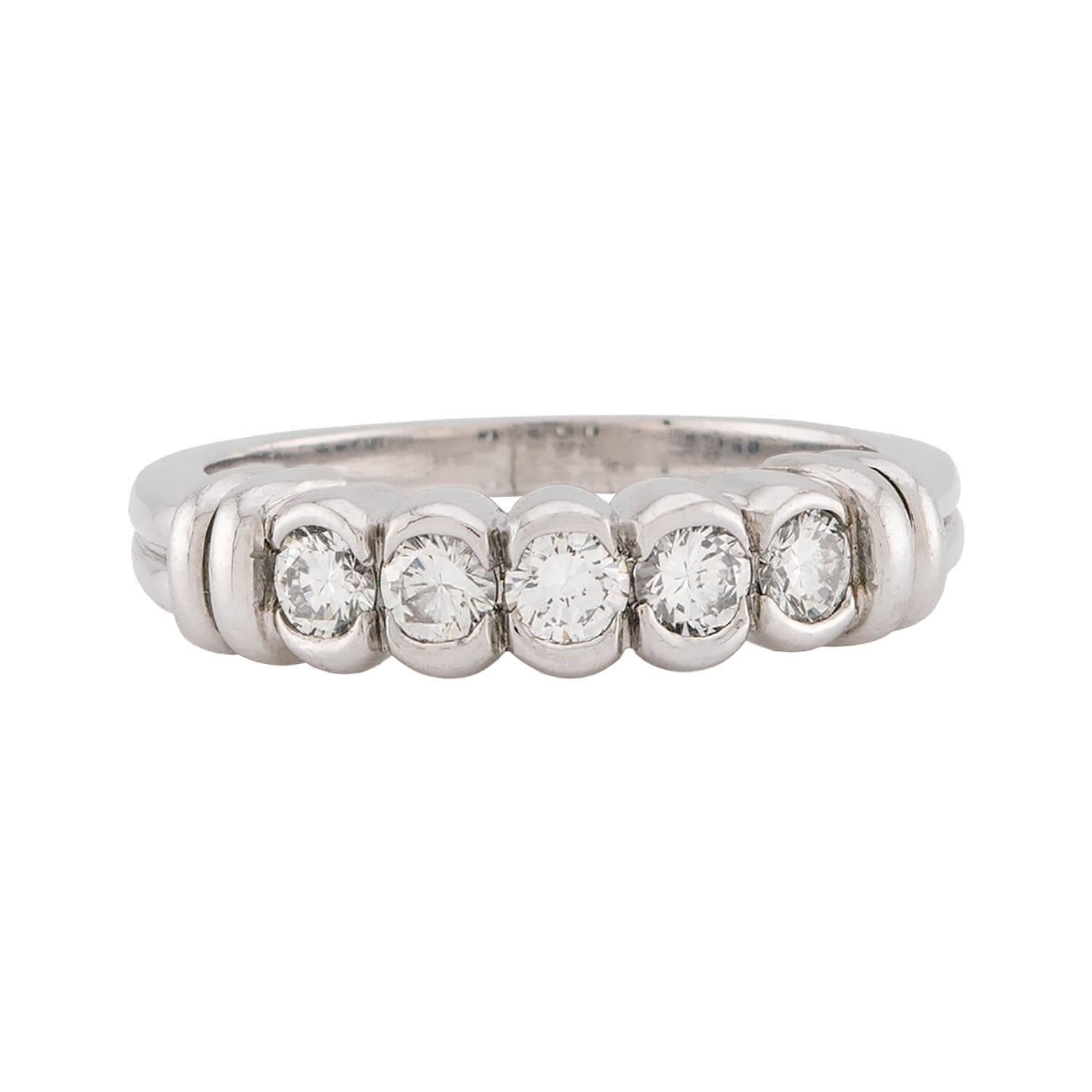 A fantastic diamond ring from designer, Scott K! Crafted in platinum, this ring features a horizontal row of five modern round brilliant cut diamonds. The diamonds are all held within bezel-settings, and have an approximate total carat weight of