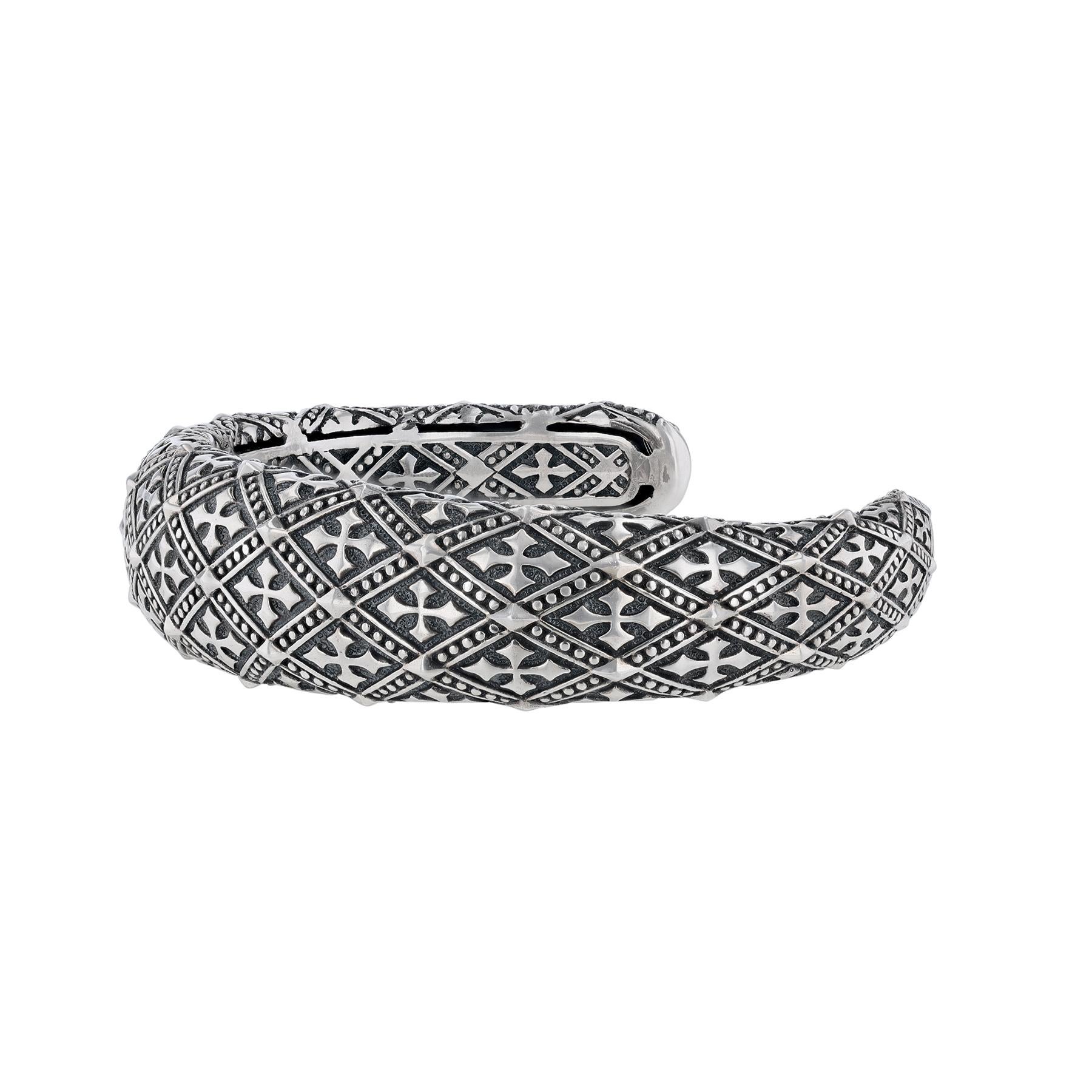 Dieses Manschettenarmband ist aus Sterlingsilber mit Kreuzen und Perlendetails gefertigt. 

