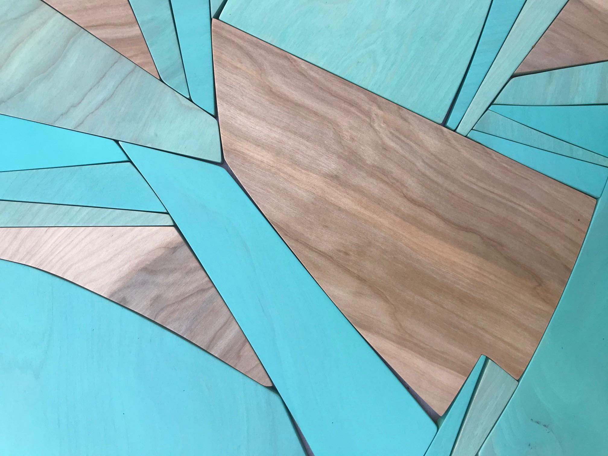 Coastal Span is a vibrant, bold, monochromatic wall sculpture made from acrylic washes, enamel and latex paints on Birch panels and MDF. The varying opacities of blue washed paint over the birch panels allow the brown wood grain to remain visible