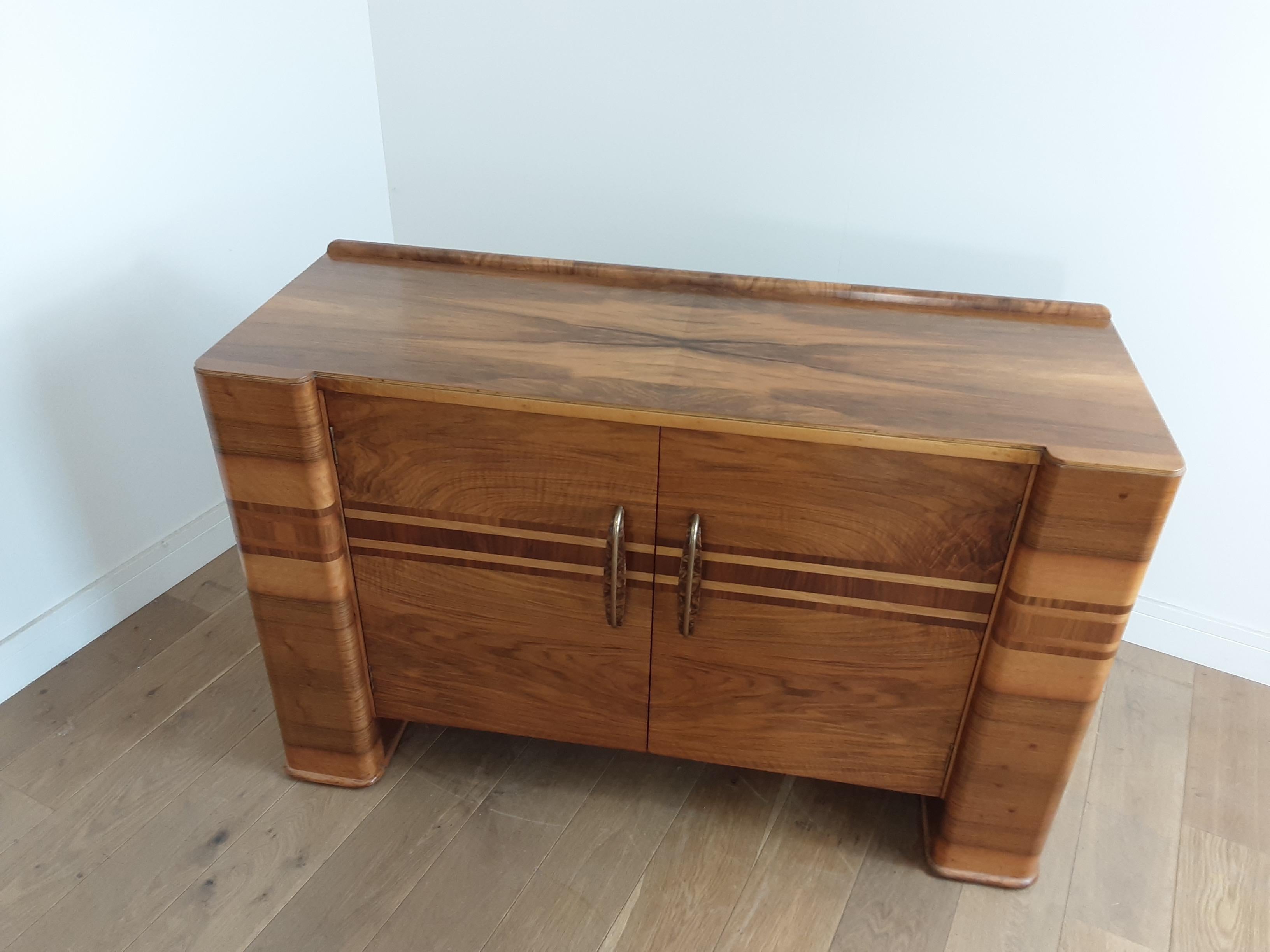 Art Deco sideboard in a smart figured and banded walnut with pillar ends.
This modernist style sideboard was made by renowned Scottish cabinet makers H Marshall & Co. from a range known as 