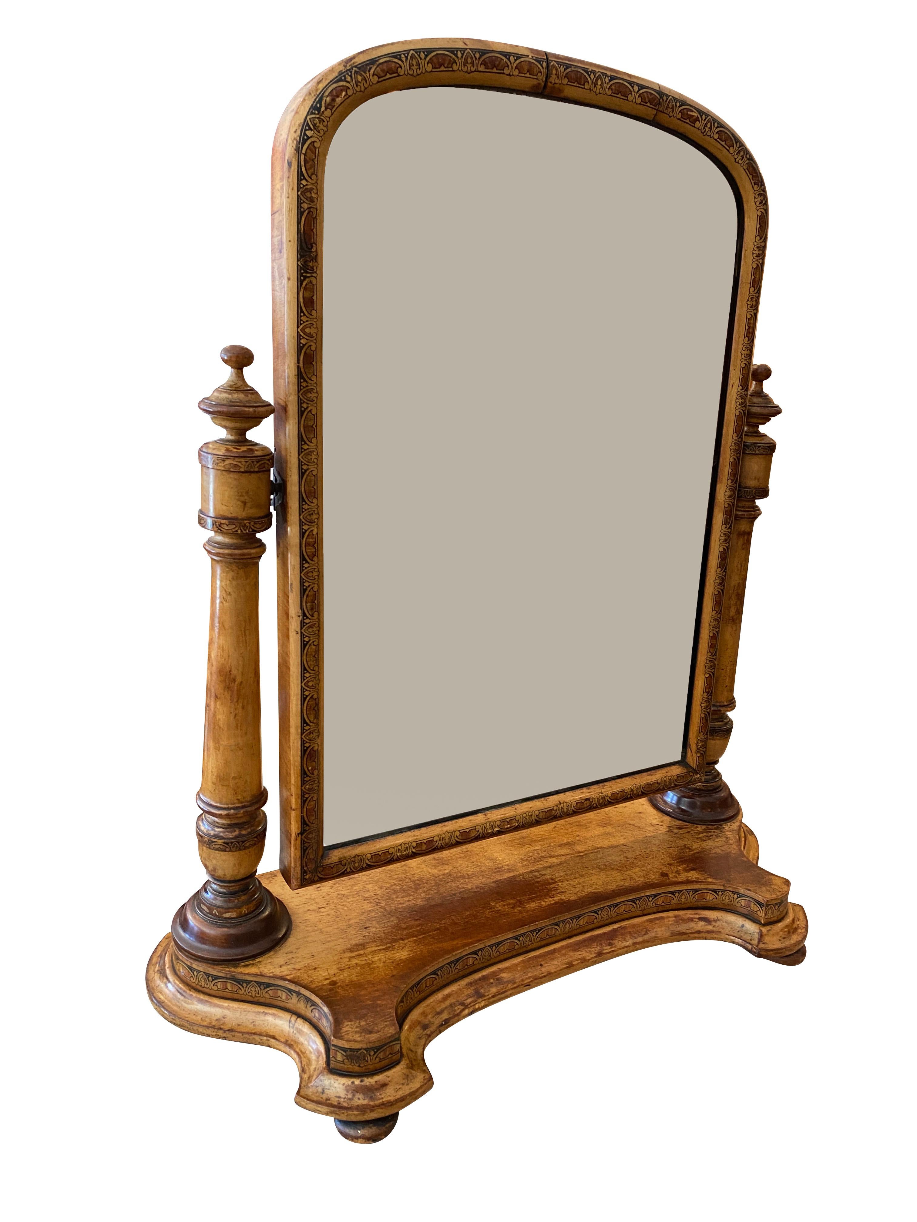 Arched mirror frame with painted decoration flanked by columns with turned finials, shaped platform base. Flat bun feet.