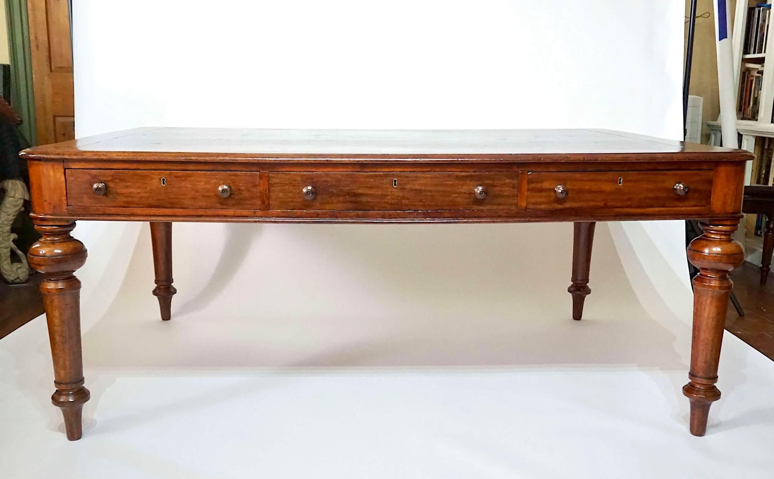 A circa 1875 Scottish solid mahogany double-sided library or writing table of very large scale and rectangular form by Glasgow cabinetmakers Francis & James Smith, LTD. (original enameled tag to an interior drawer as shown), the original black