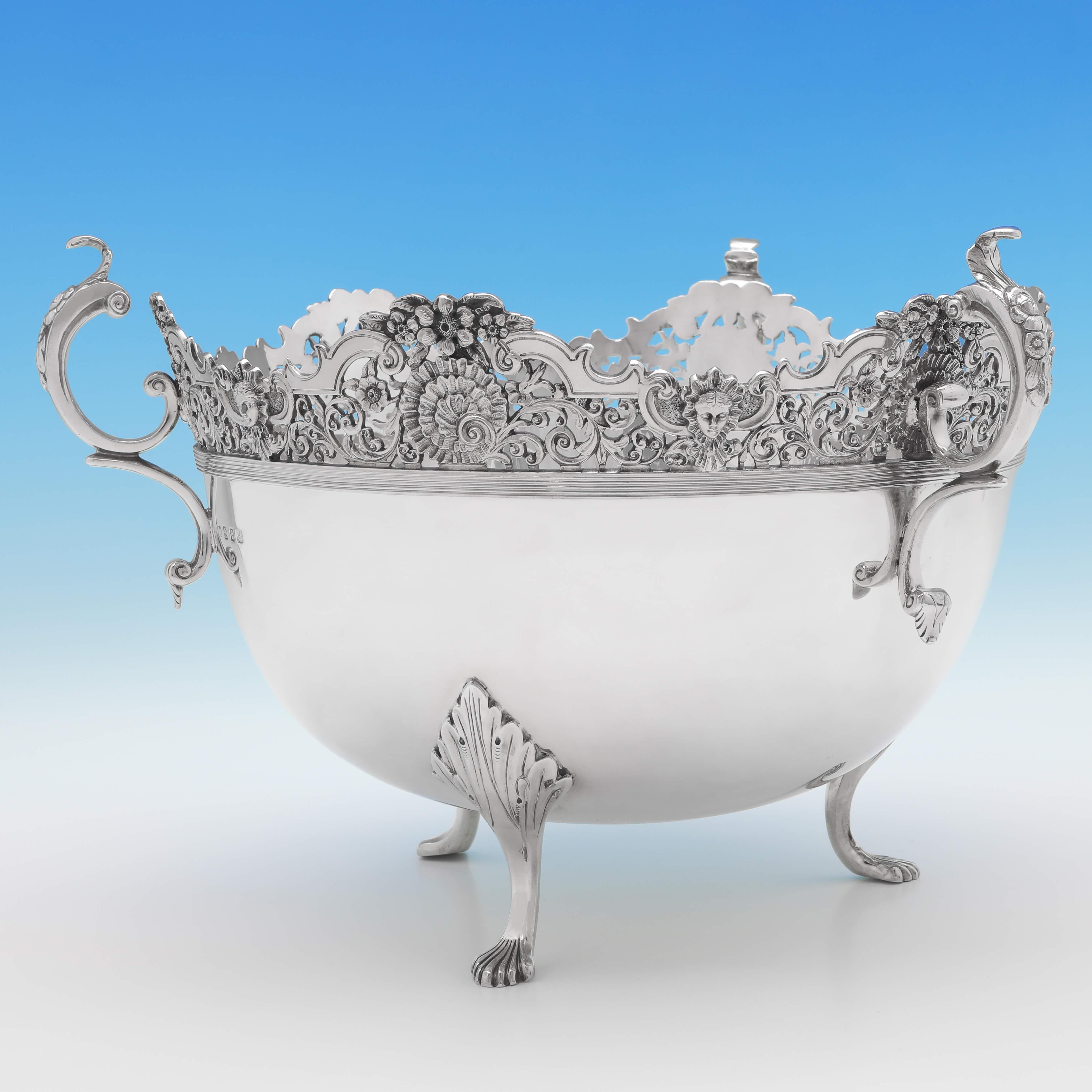 Hallmarked in Glasgow in 1907 by James Weir, this unusual, Edwardian, antique sterling silver bowl, stands on three feet, and features a cast pierced top, reed detailing and three acanthus decorated scroll handles. The bowl measures 9.25