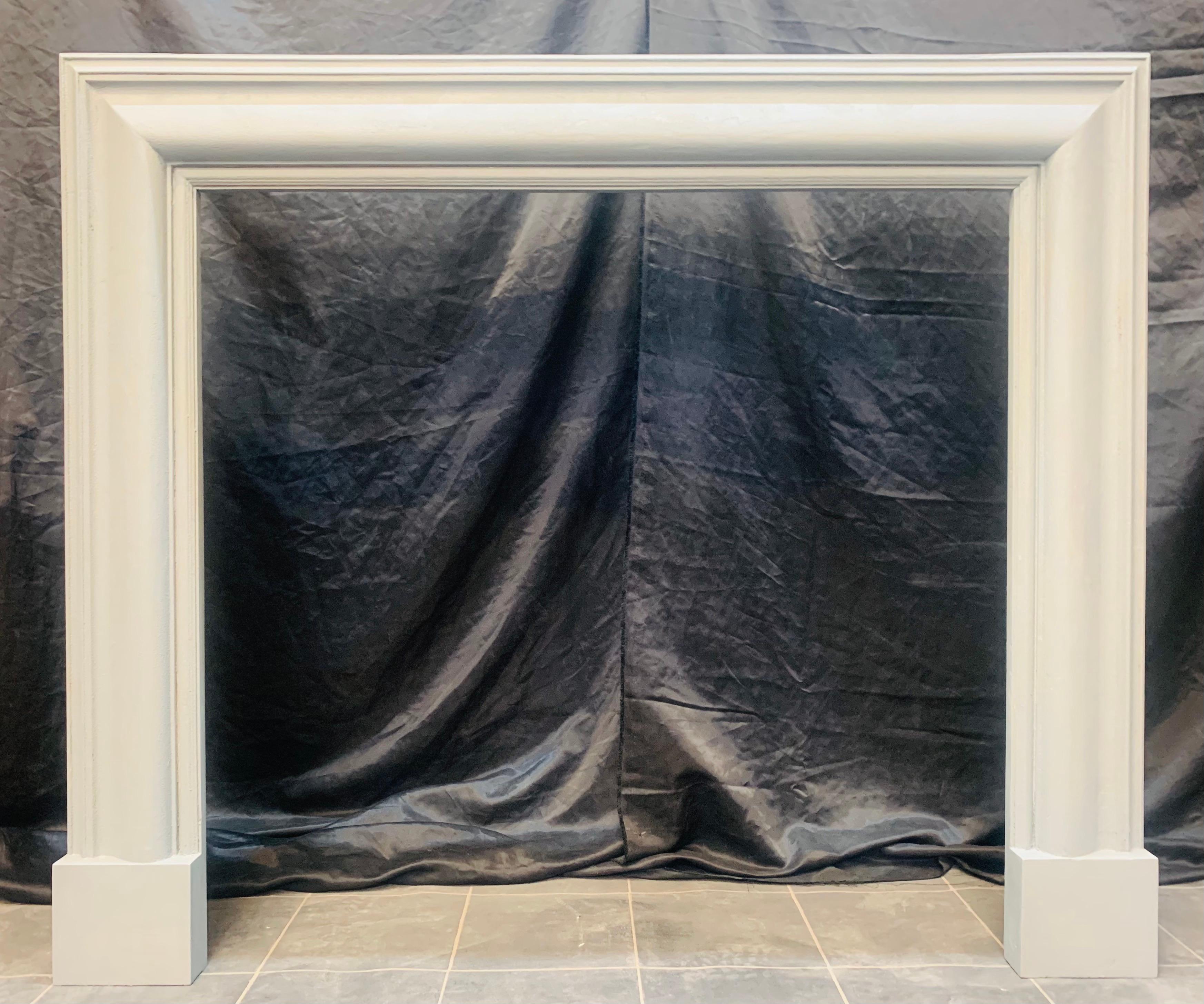A smart Edwardian hardwood (oak) bolection fireplace surround, undercoated French grey. A simple bolection moulded frame with a return to wall section, all mounted on plain foot blocks. 
Edinburgh, Scotland 1900. 

Skirting block height: 155mm high.